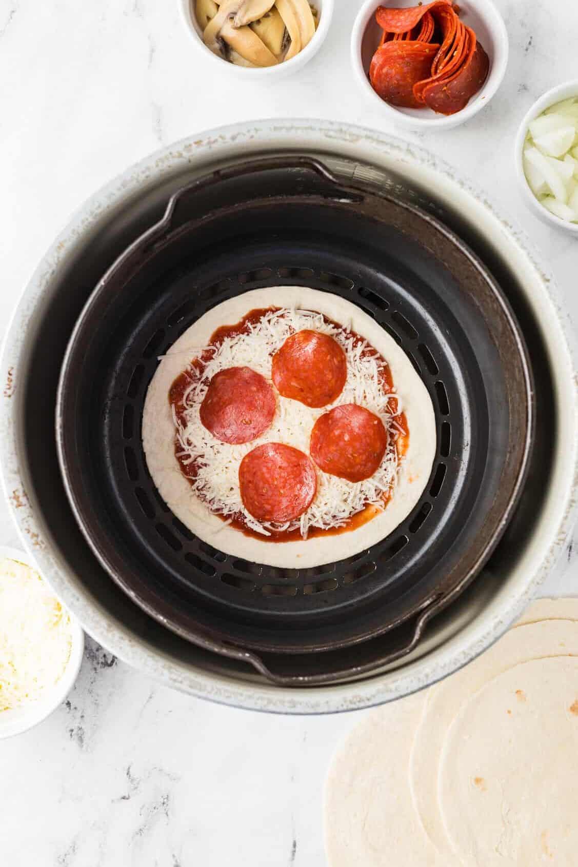 pepperoni on tortilla pizza in air fryer basket