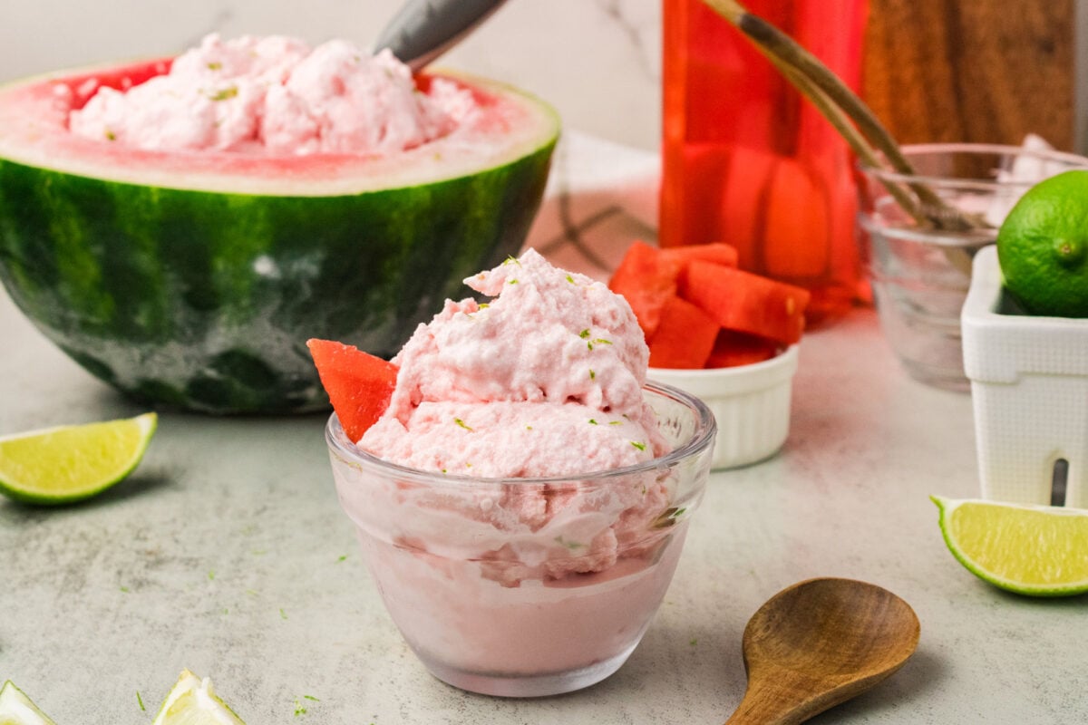 watermelon ice cream in a serving bowl with a watermelon in the background