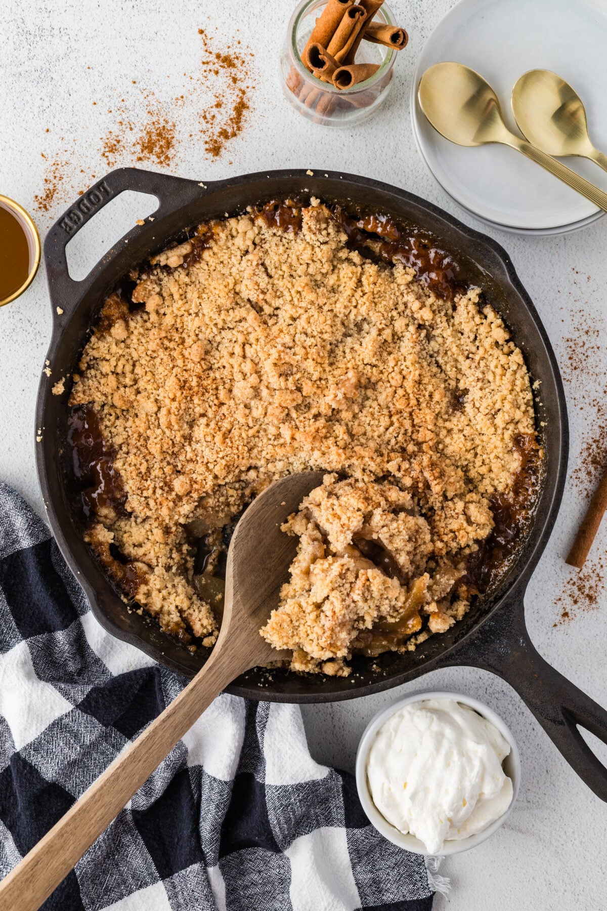 wooden spoon in skillet of fresh baked apple crisp without oats