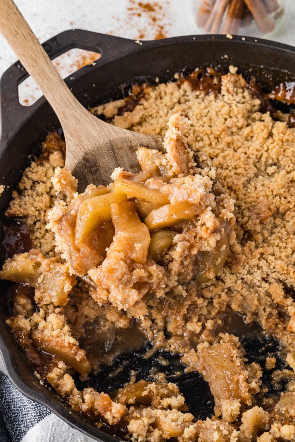 oatless apple crisp in a skillet with a spoon dipping some out