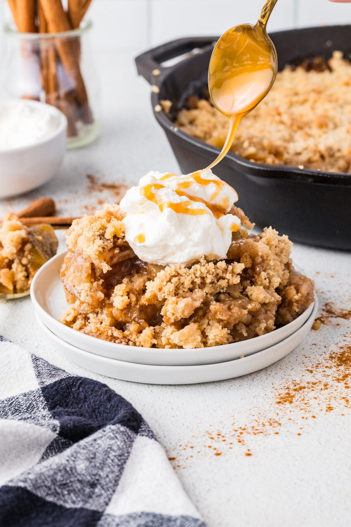 apple crisp with ice cream and caramel being drizzled over the top