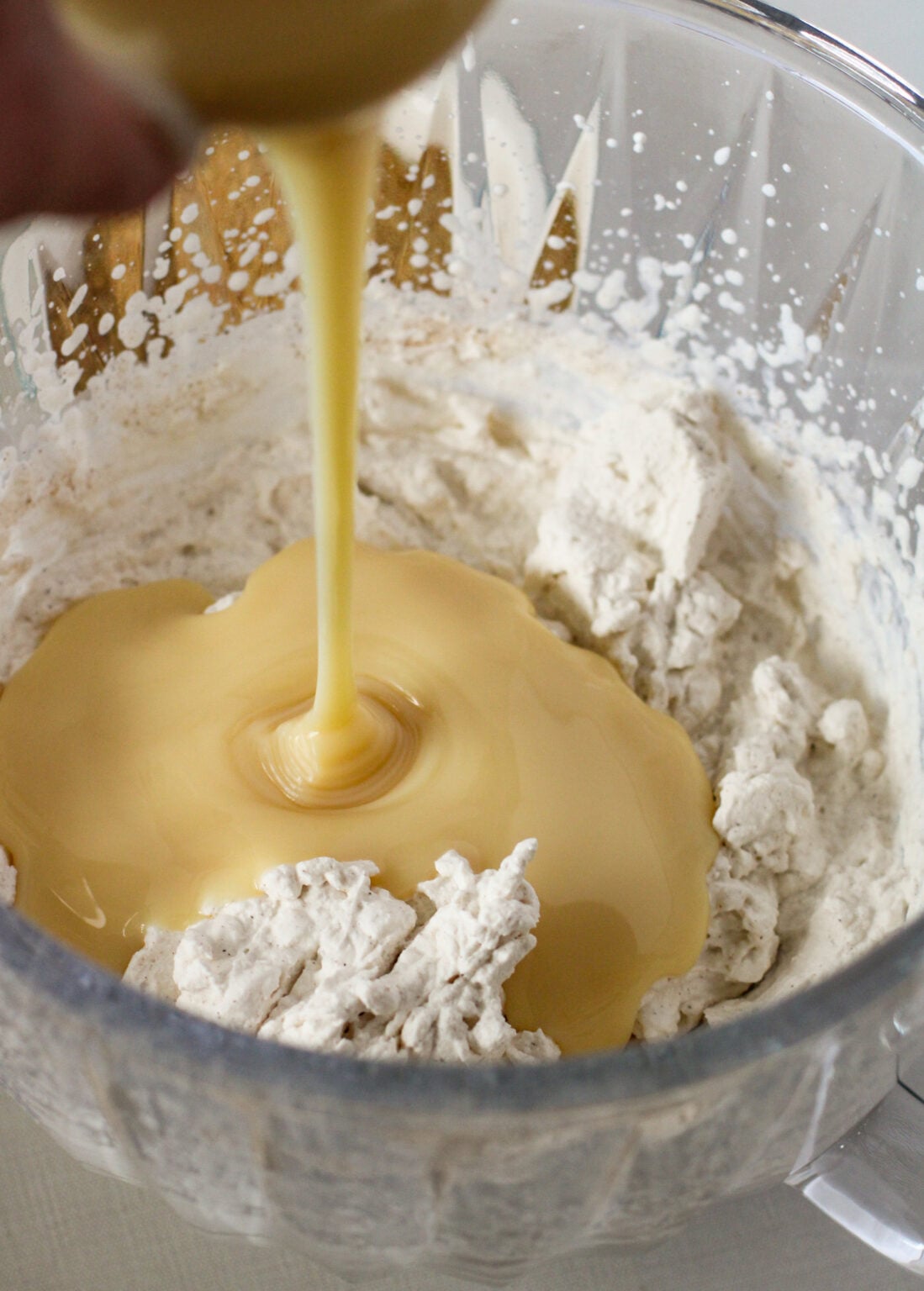 adding condensed milk to the whipped cream mixture