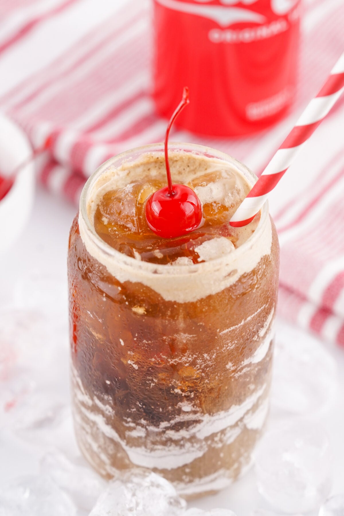 fluffy coke with a cherry and a straw