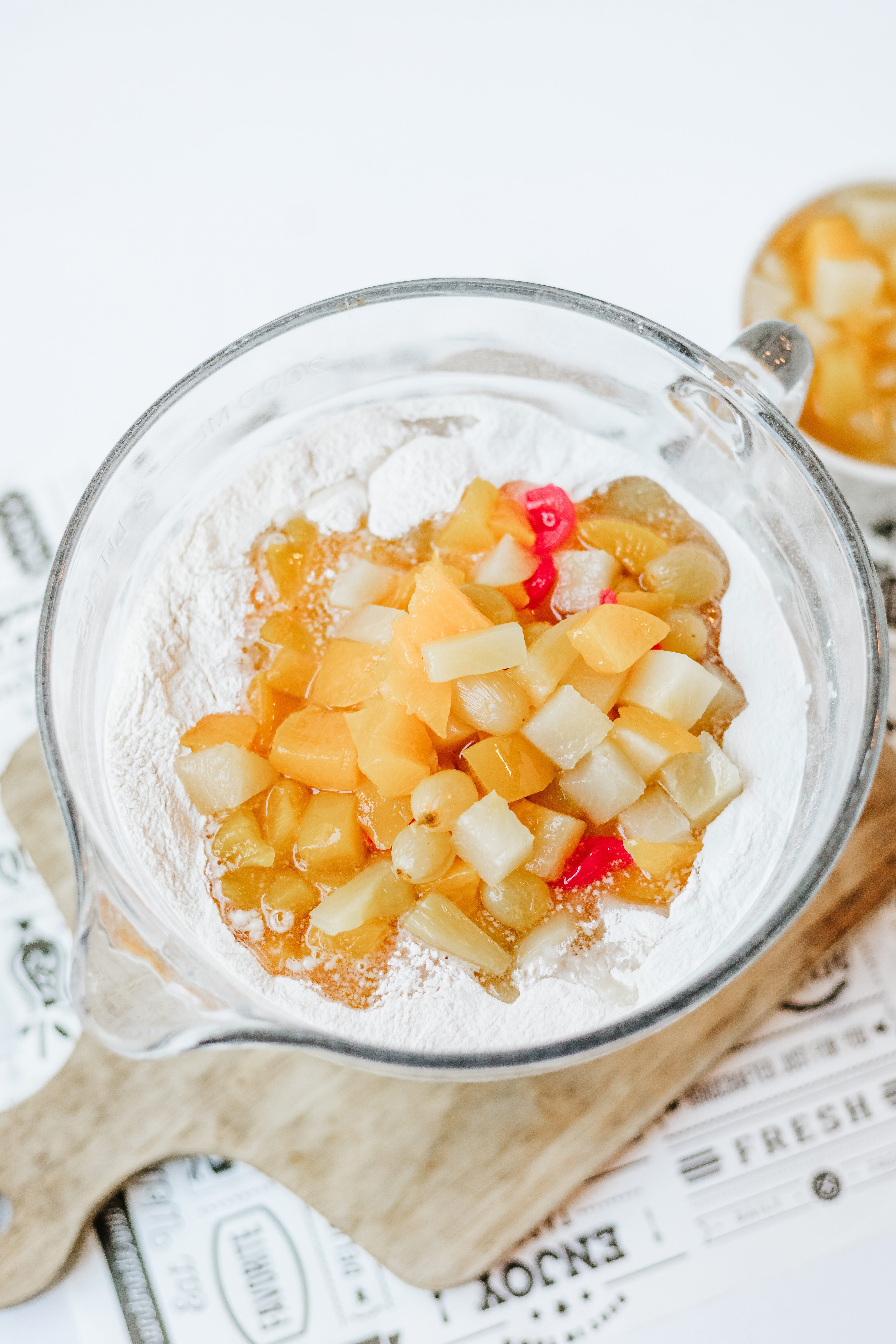fruit cocktail added to dry ingredients in a mixing bowl