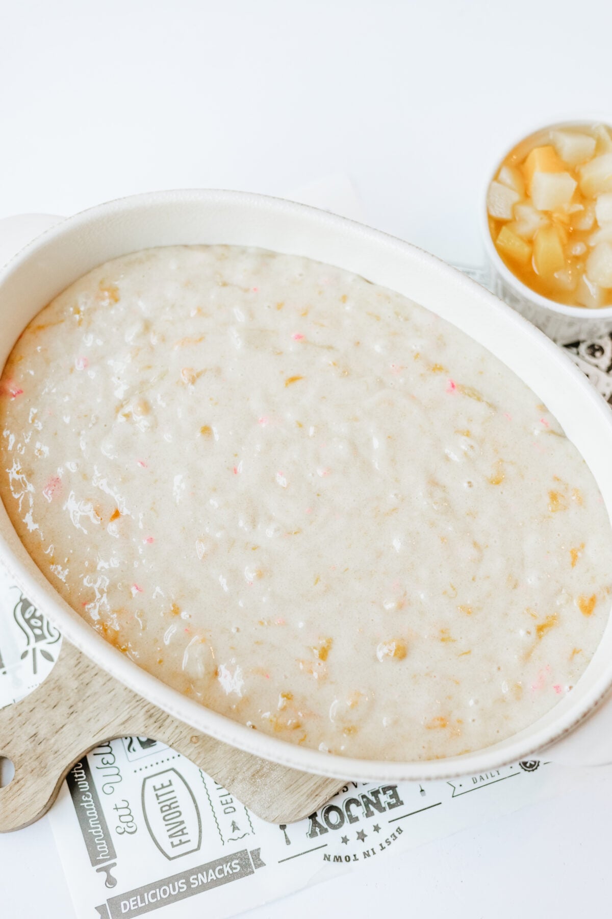 fruit cocktail cake batter in an oval baking dish