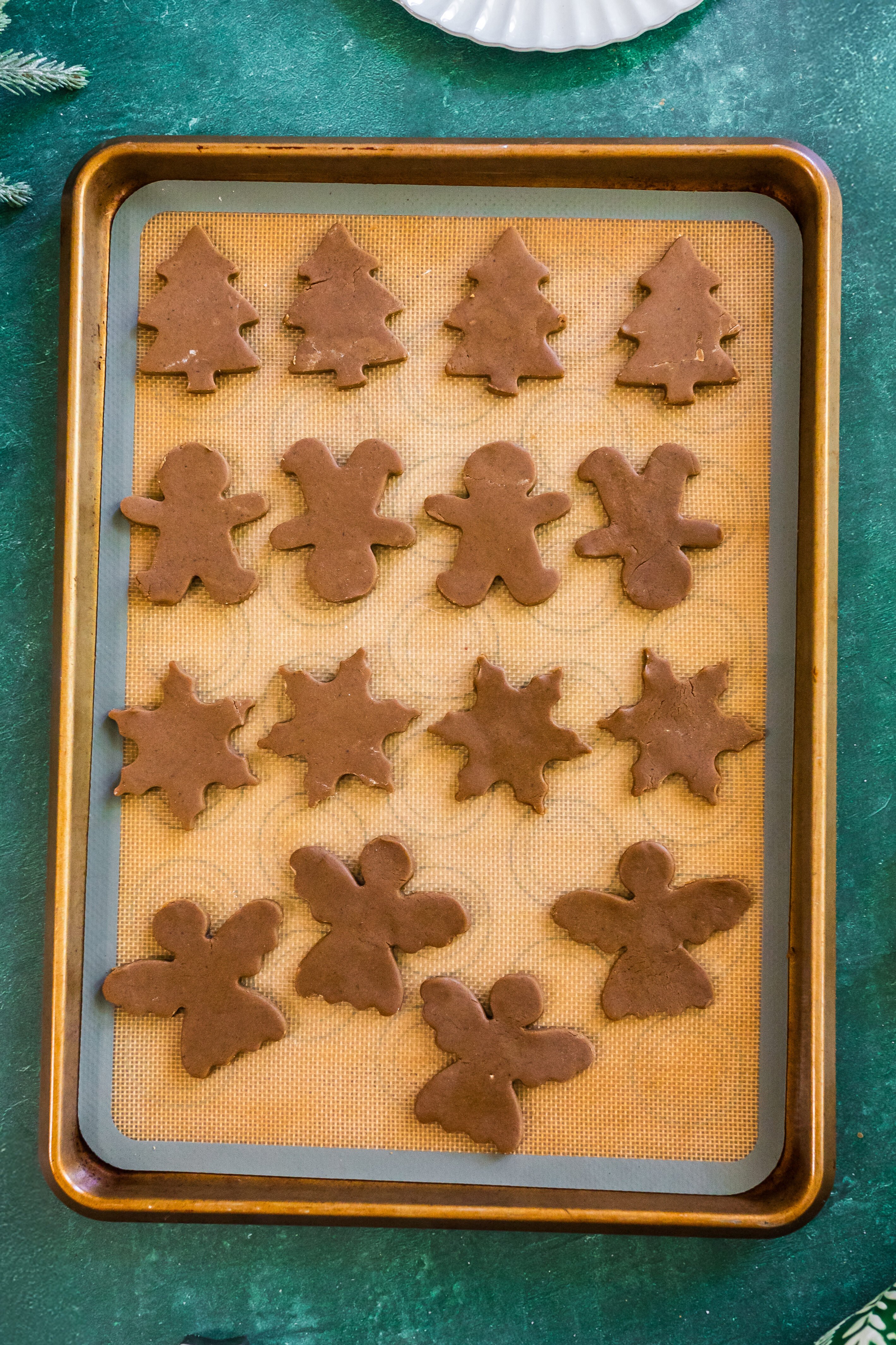 cutout cookies on a silicone mat on a baking sheet