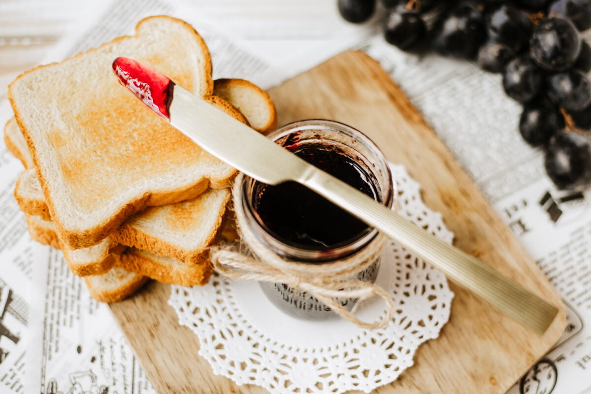 grape jelly on a butter knife over toast