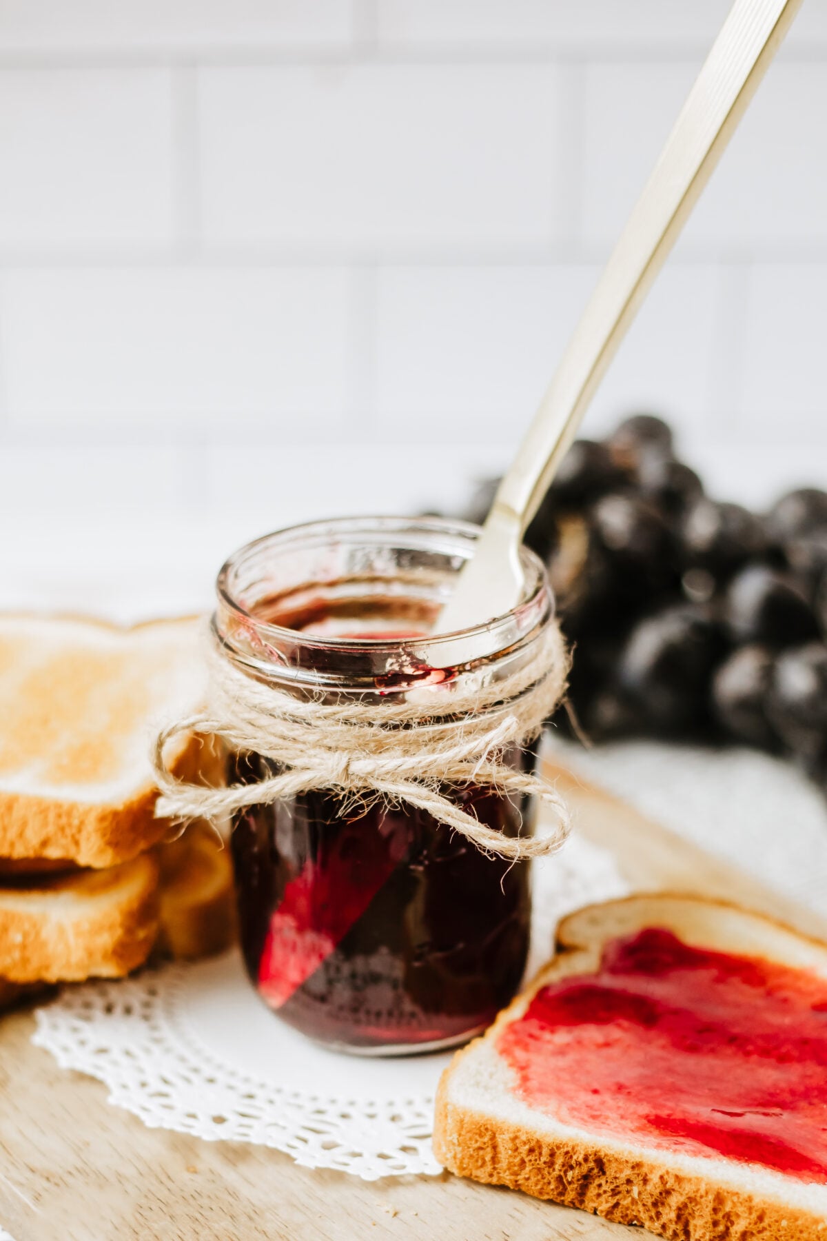 grape jelly in a half pint jar with a butter knife in the jar
