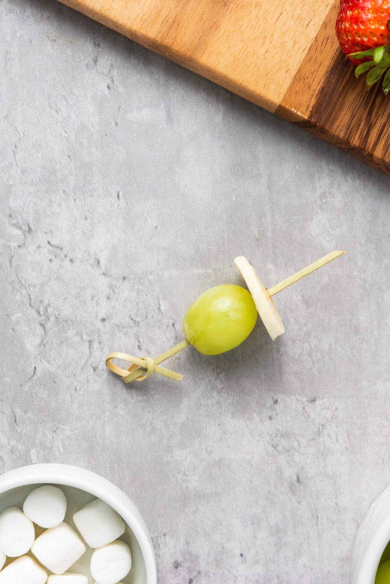 slice of banana next to grape on skewer