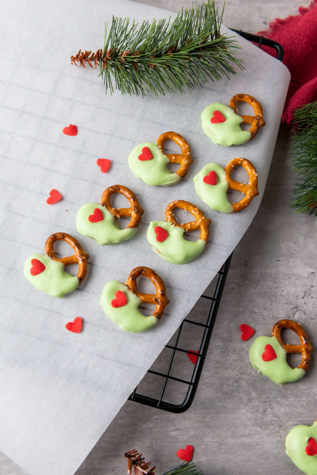 grinch pretzels on parchment paper laying on a cooling rack