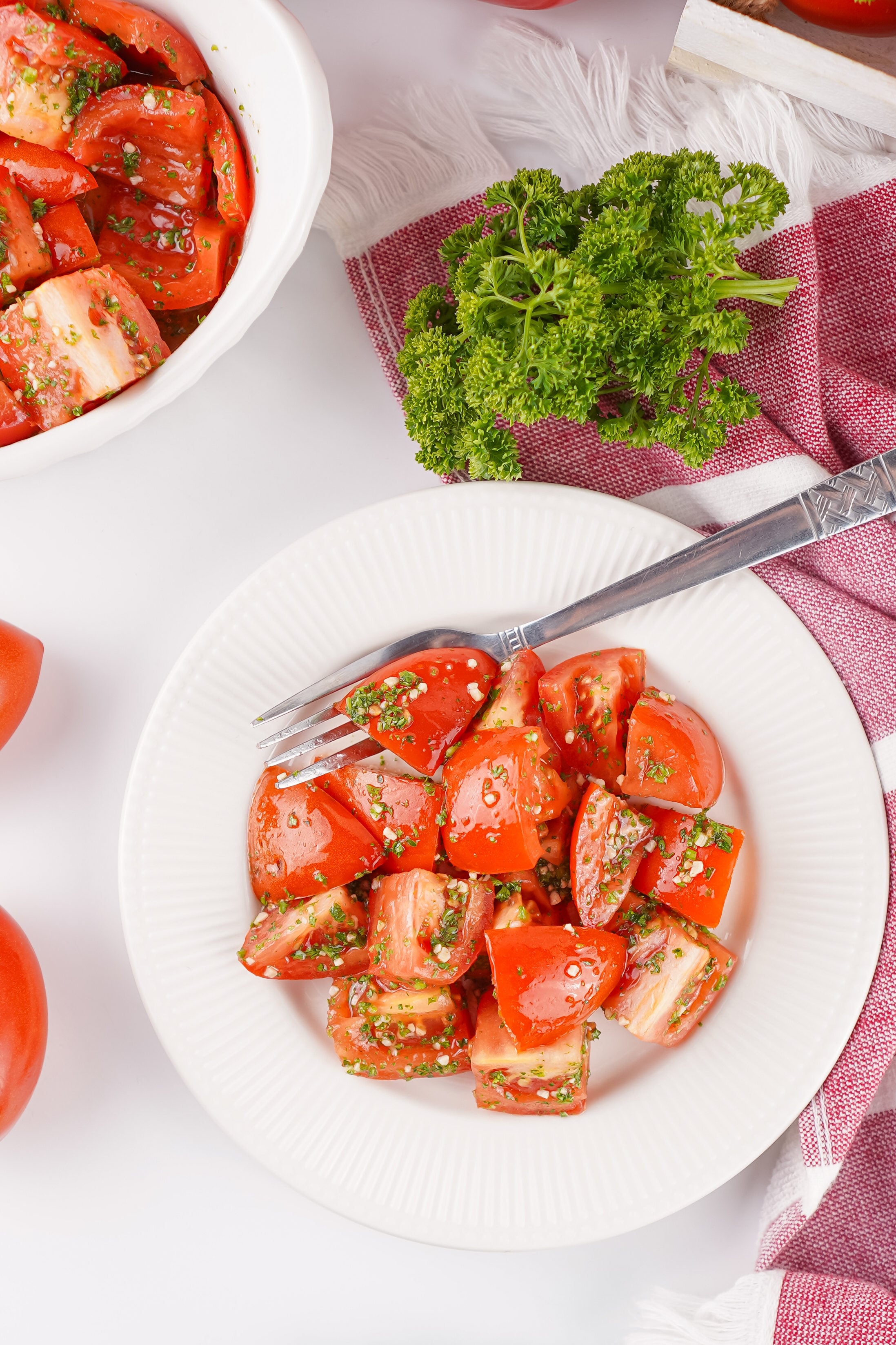 bowl of marinated tomatoes with a fork