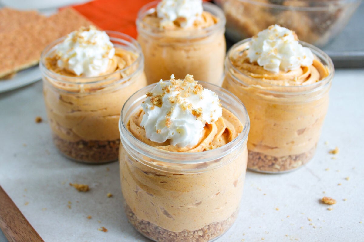 no bake pumpkin cheesecake cups with whipped cream on top