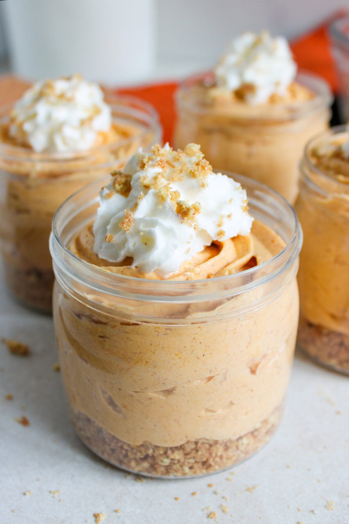 no bake pumpkin cheesecake cups with whipped cream on top