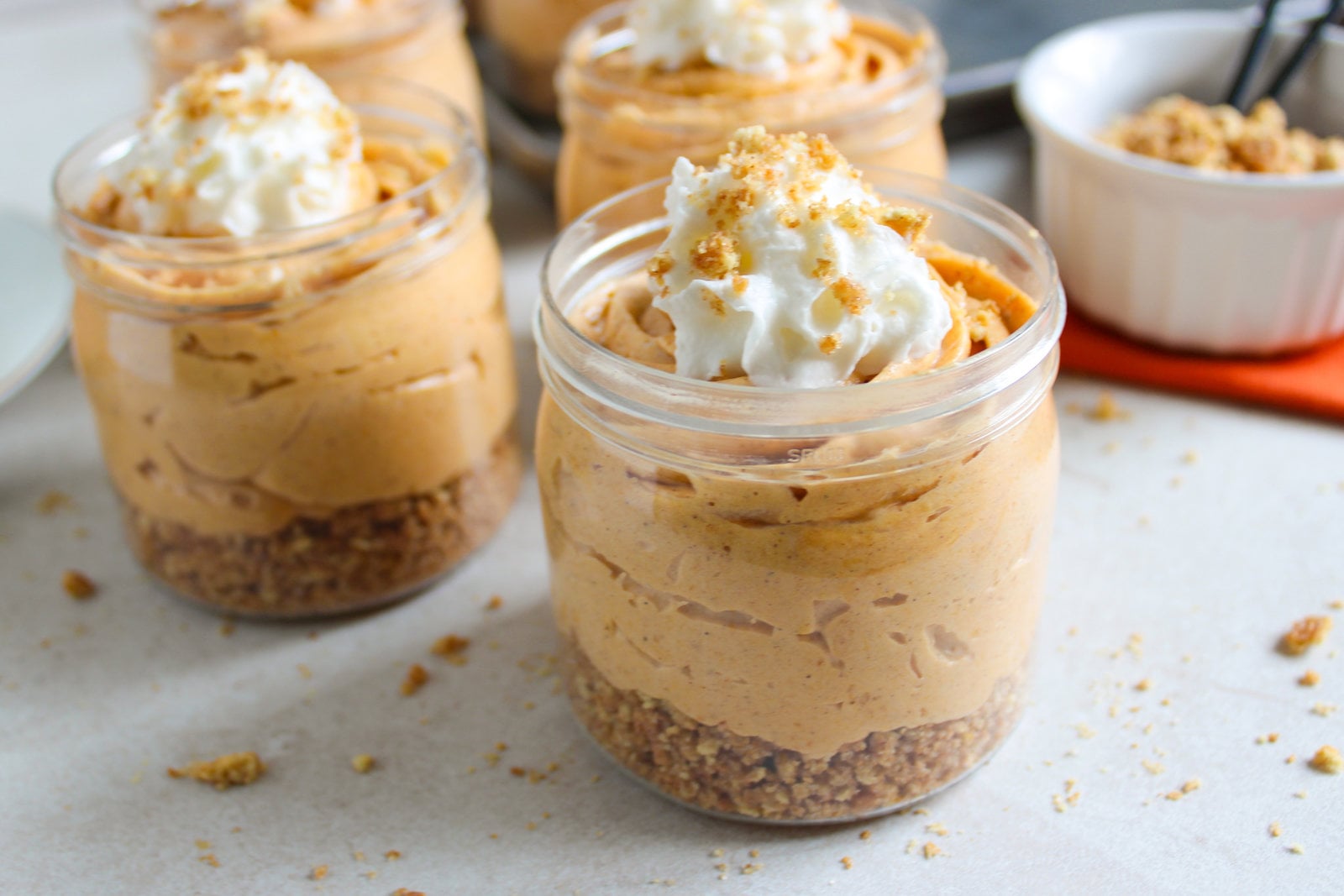 no bake pumpkin cheesecake cups with whipped cream on top