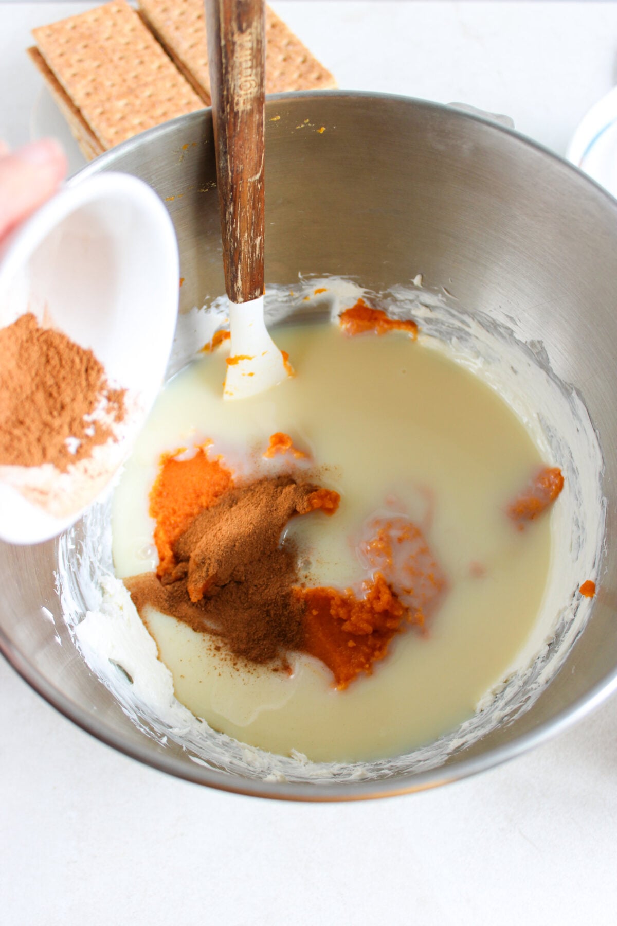 adding spices to mixing bowl