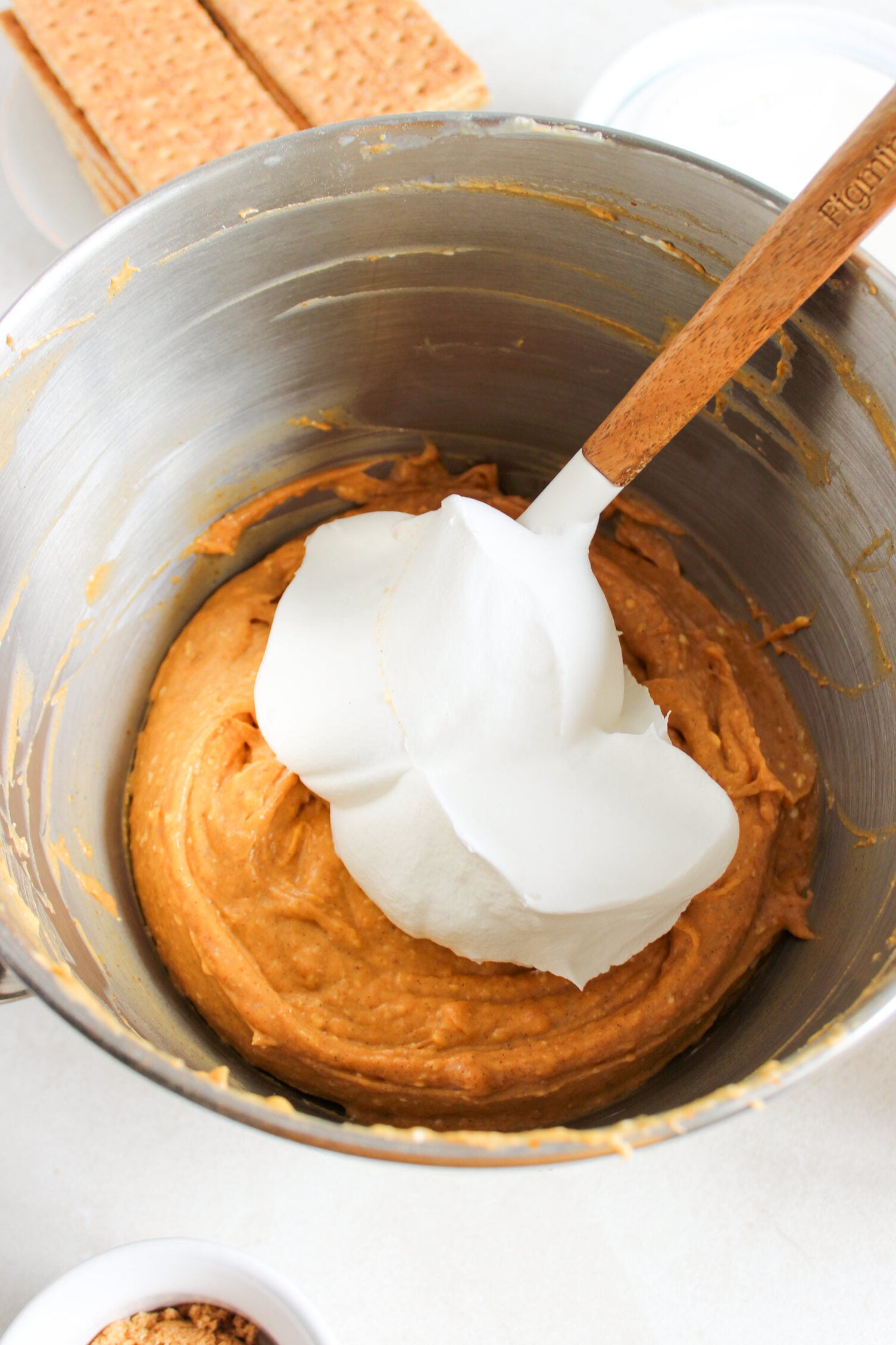 adding whipped cream to pumpkin mixture