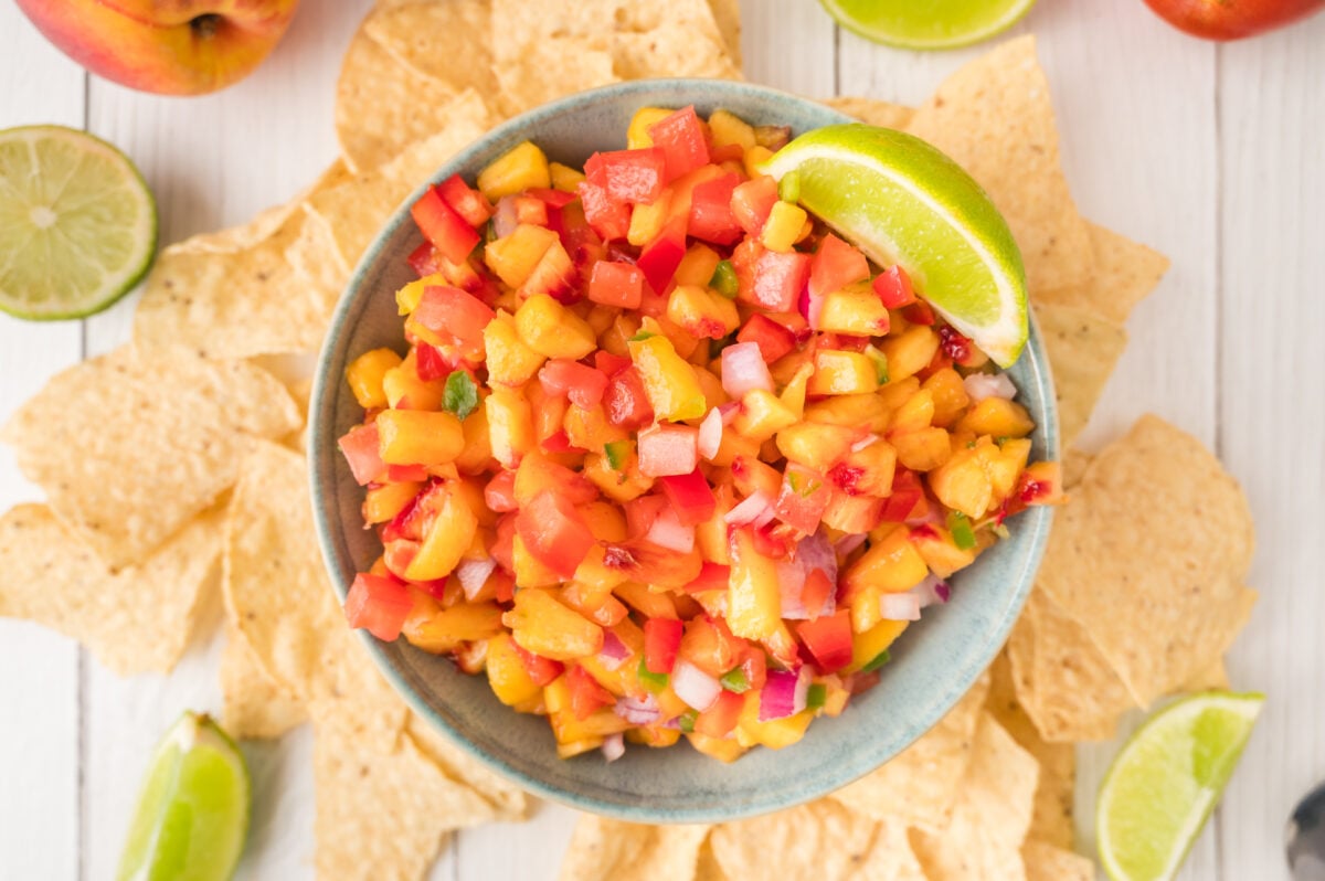bowl of peach salsa surrounded by tortilla chips