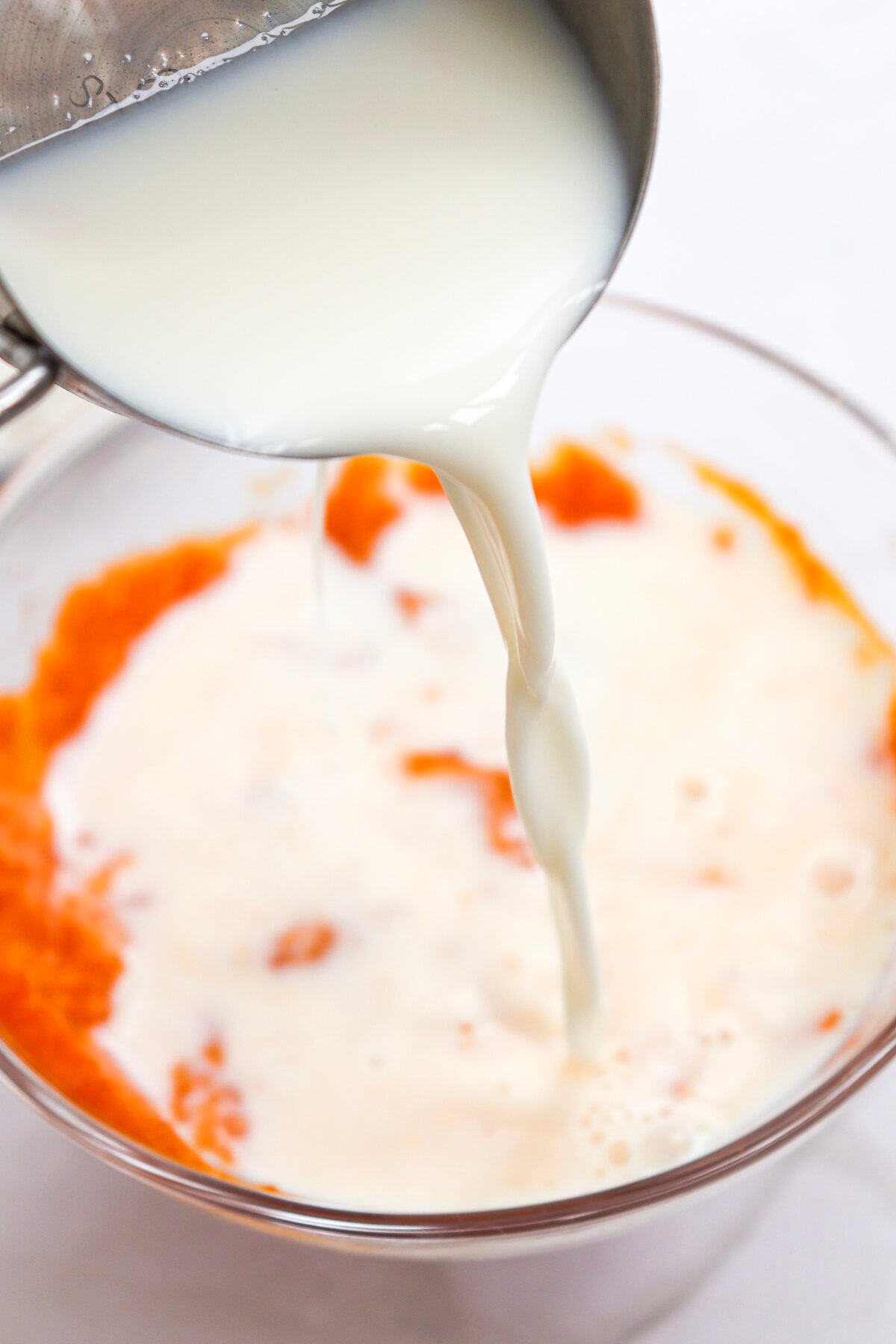 milk being added to pumpkin pancake batter