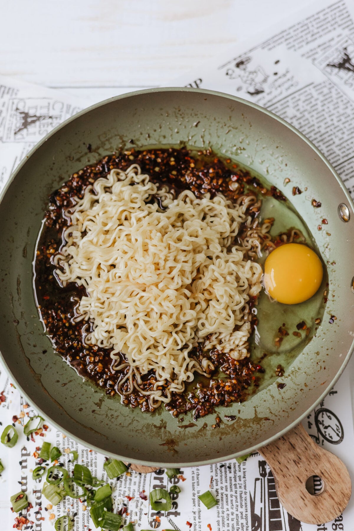 egg added to skillet with ramen and sauce