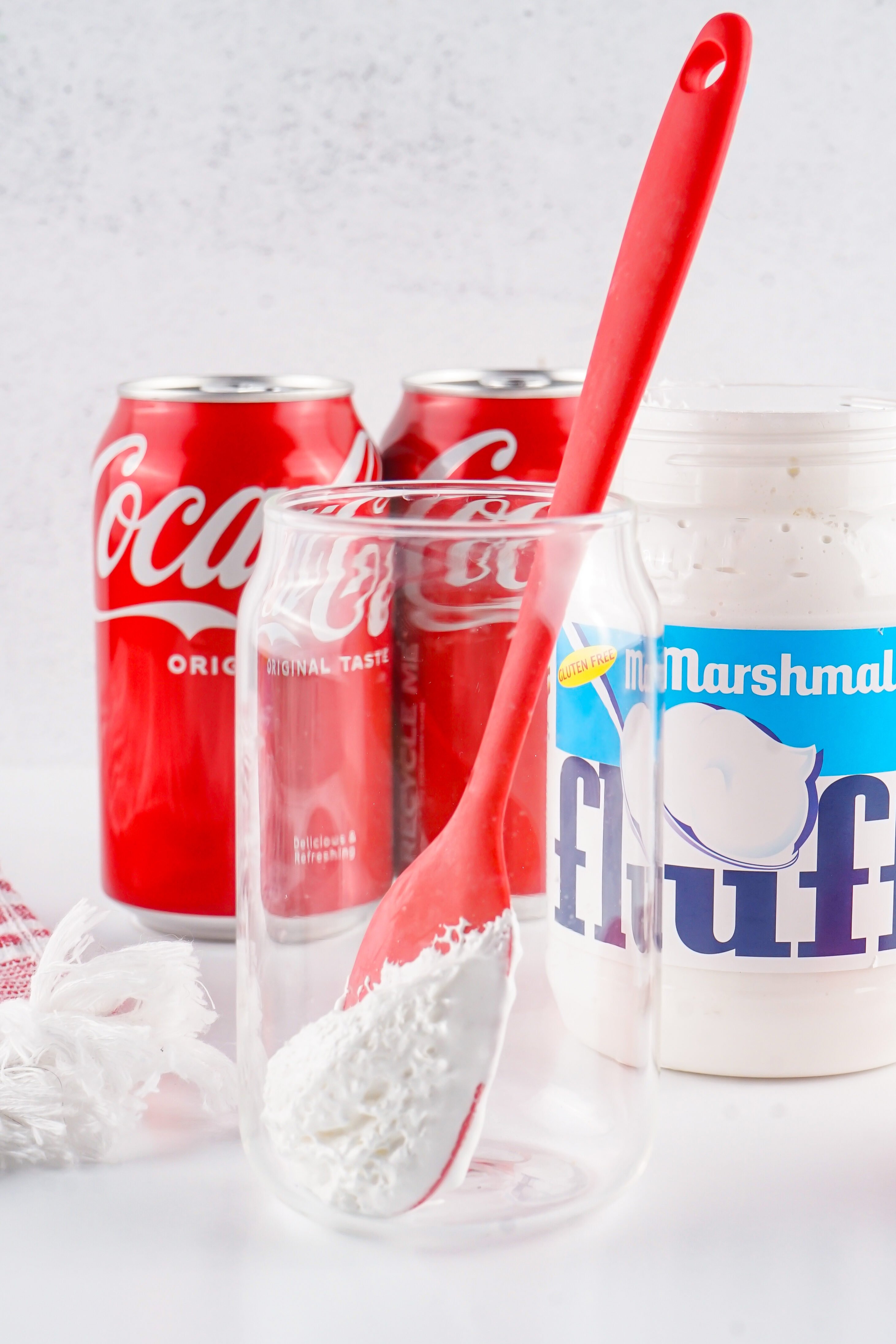 silicone spoon with marshmallow creme on it in a glass