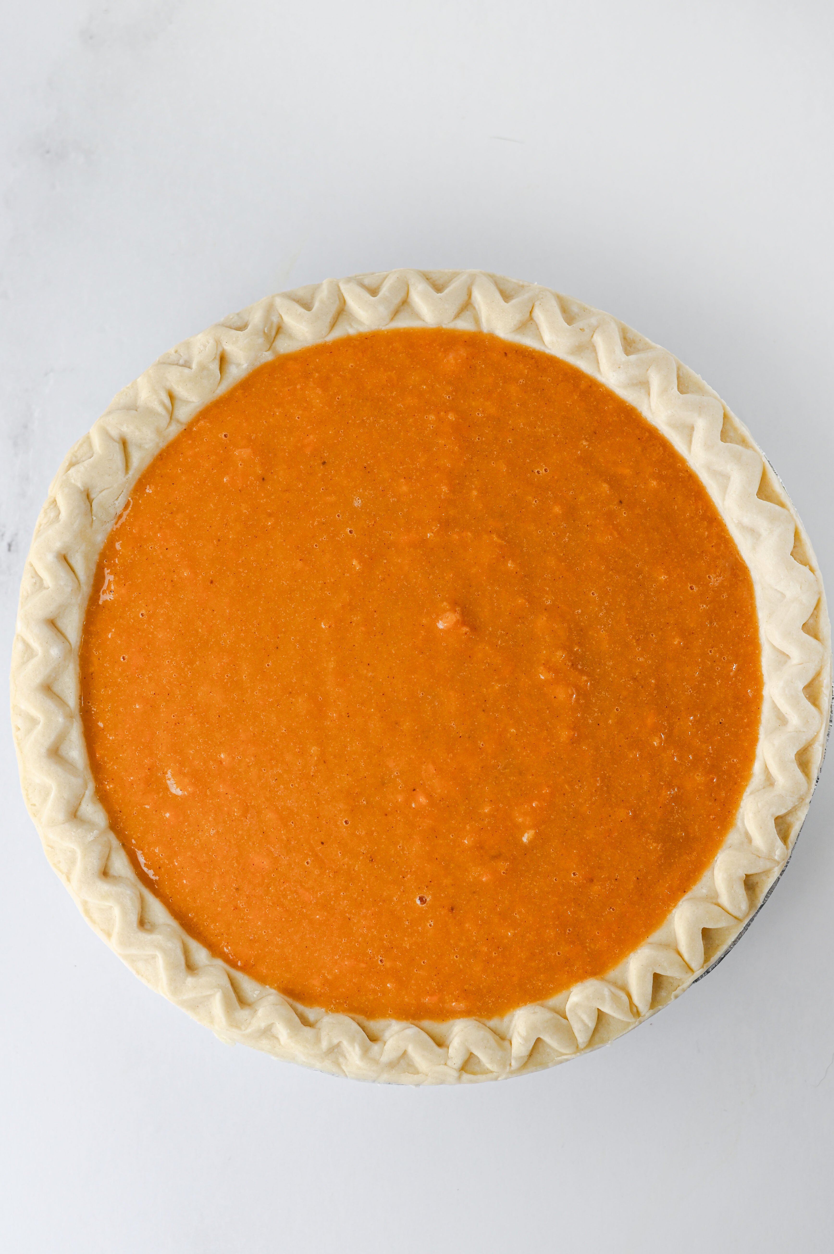 sweet potato pie filling poured into unbacked pie crust