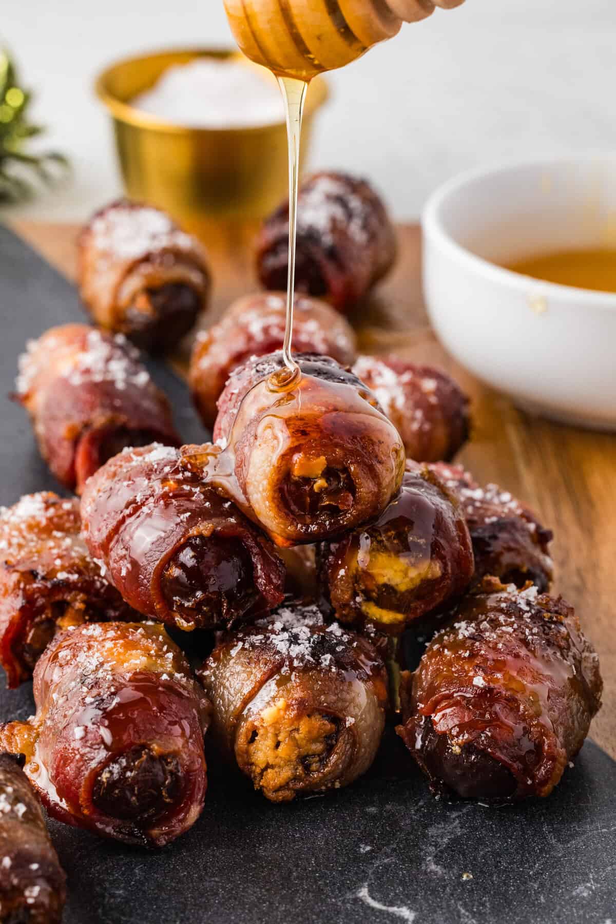 bacon wrapped dates with sea salt and honey drizzled over the top
