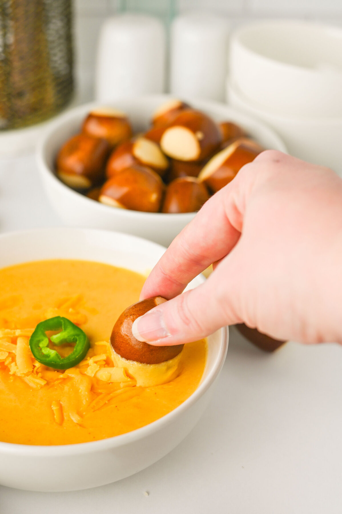 dipping pretzel bite into beer dip