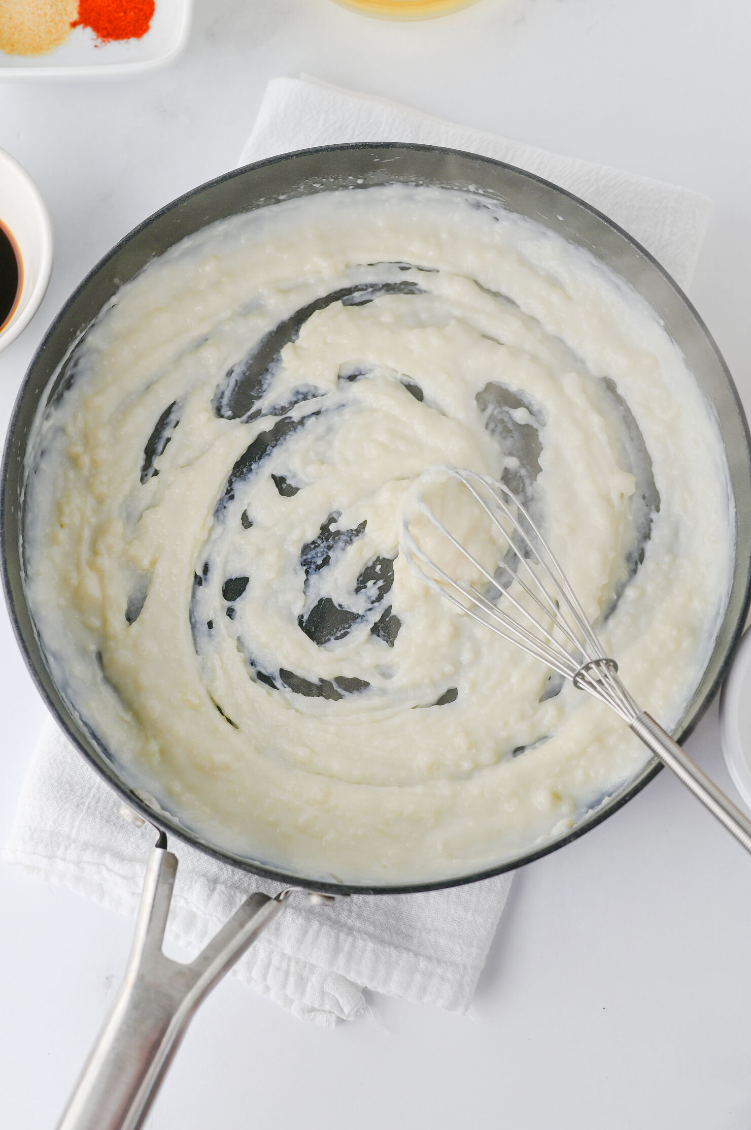 whisking milk into the flour and butter paste