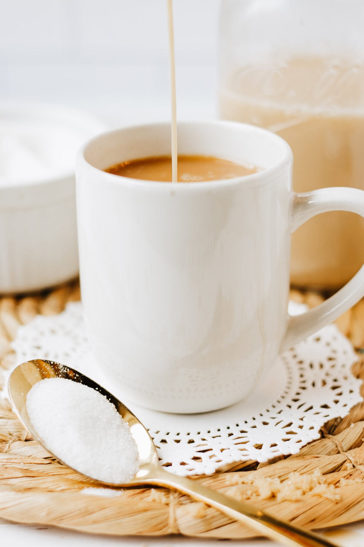 creamer being poured into coffee in a mug