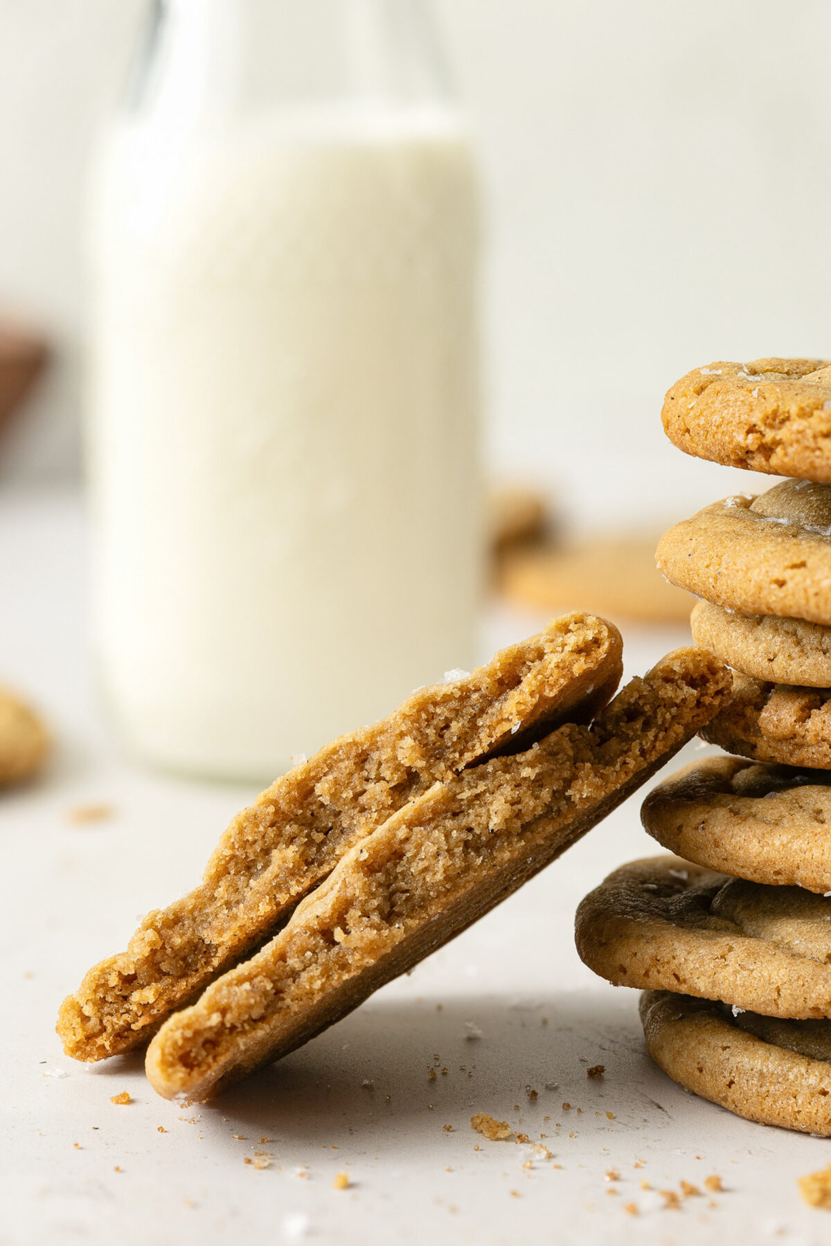 stack of brown sugar cookies with milk in the background