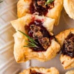 cranberry brie bites with spiced pecans and a sprig of rosemary