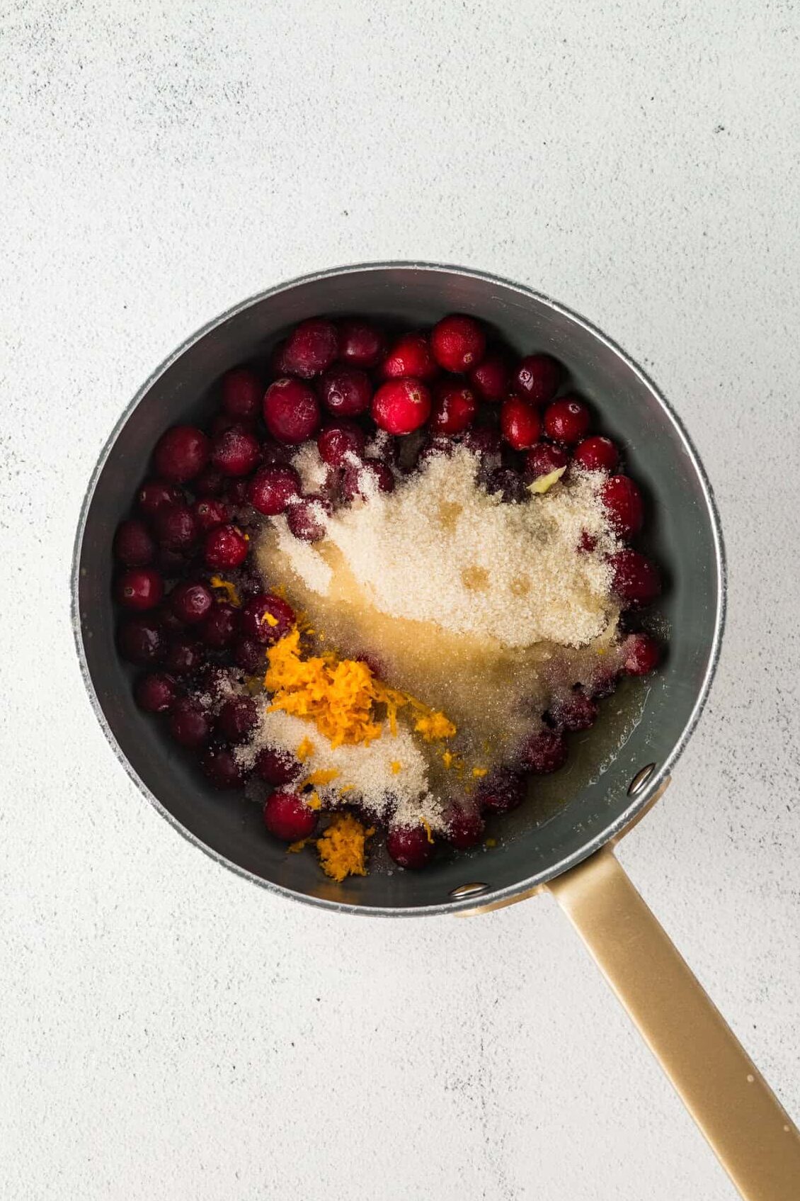 ingredients for cranberry sauce in a sauce pan