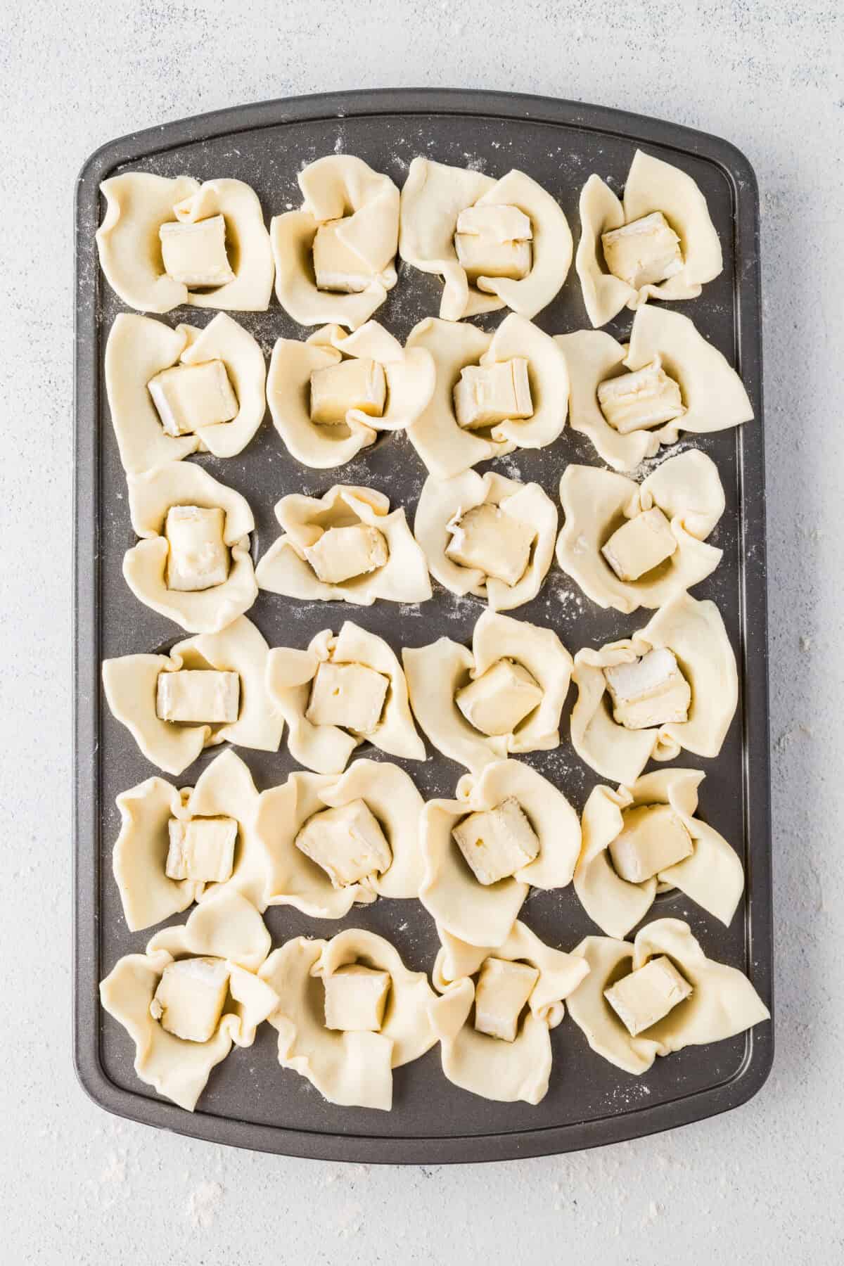 cubed brie cheese pressed into each pastry cup
