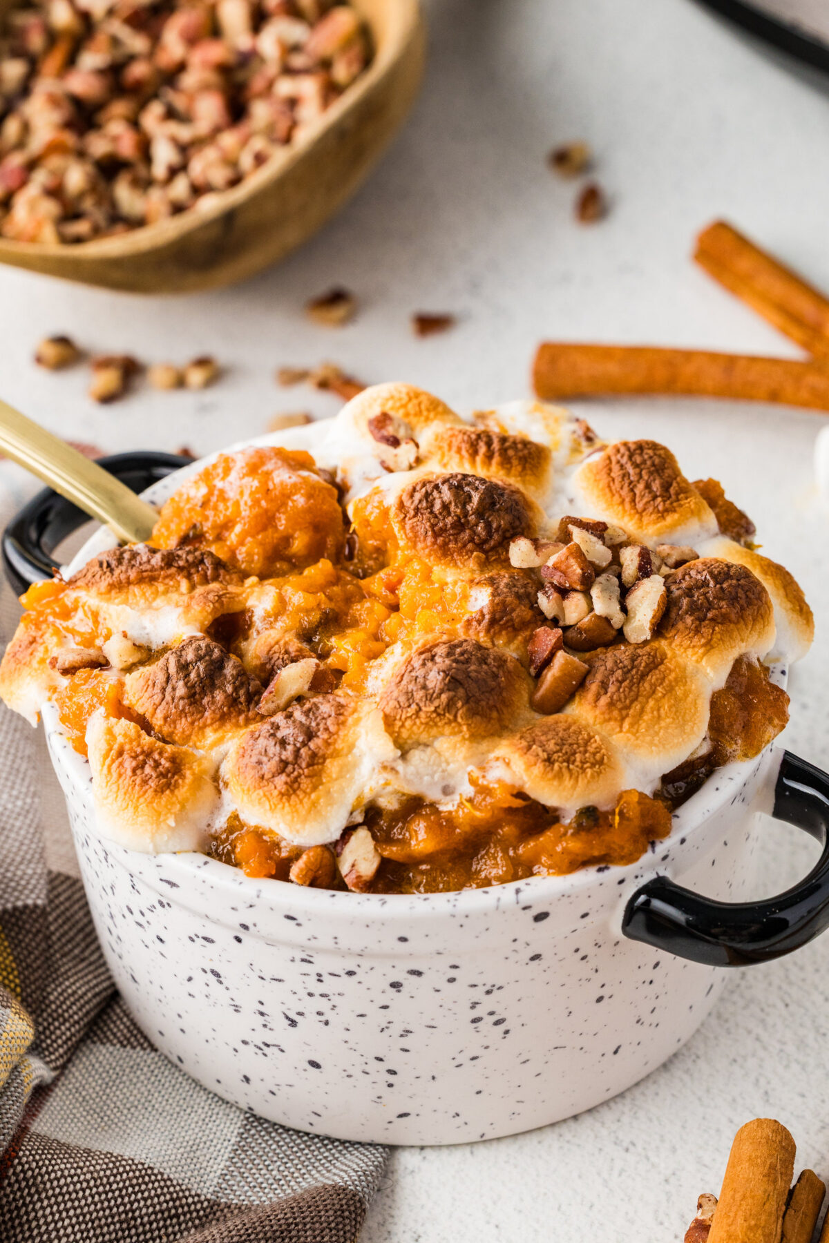 small ramekin of sweet potato casserole with toasted marshmallows and pecans on top