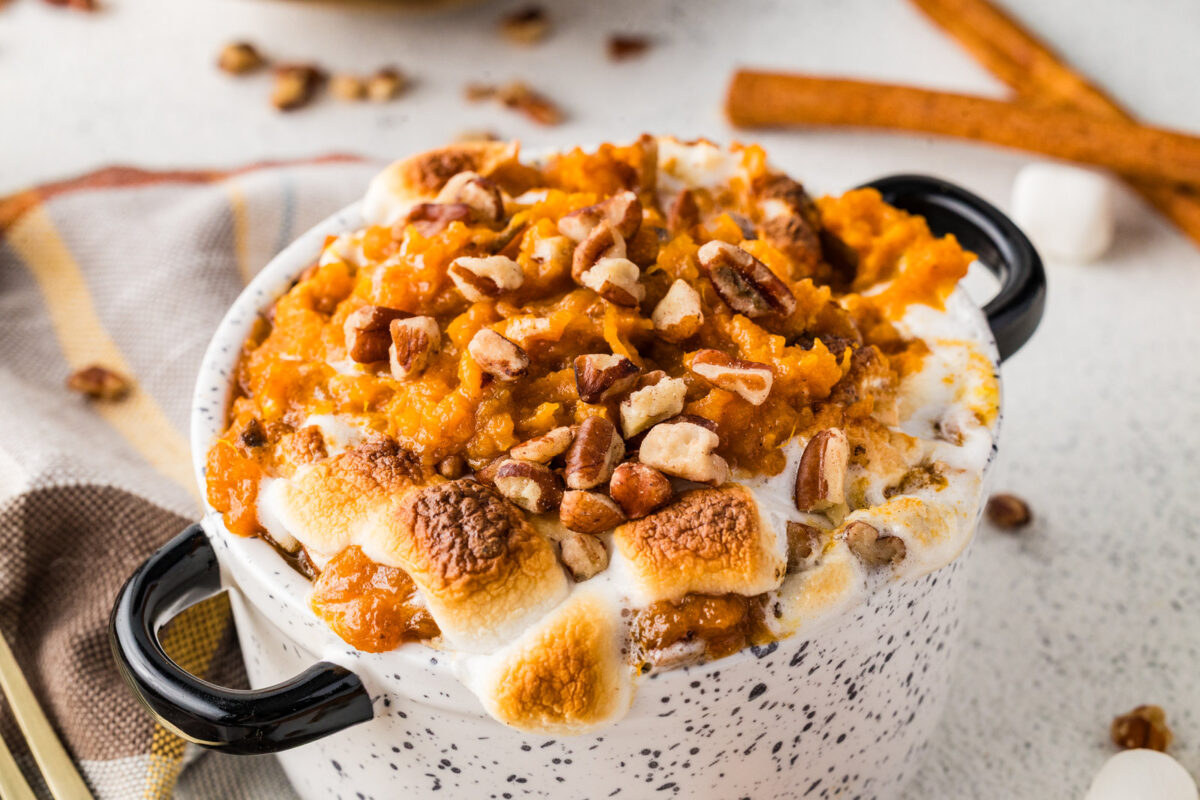 small ramekin of crockpot sweet potato casserole with toasted marshmallows and pecans on top