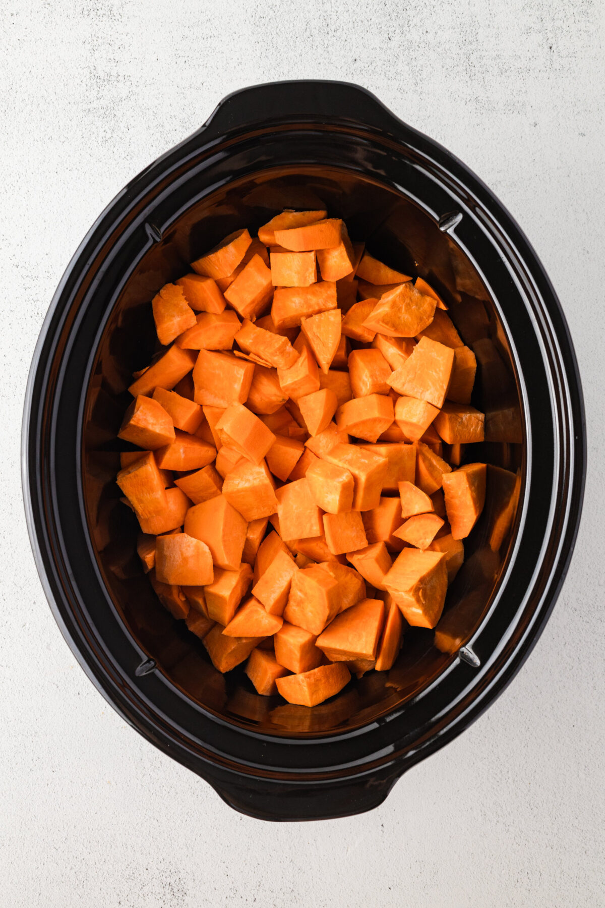 cubed sweet potatoes in a crockpot dish