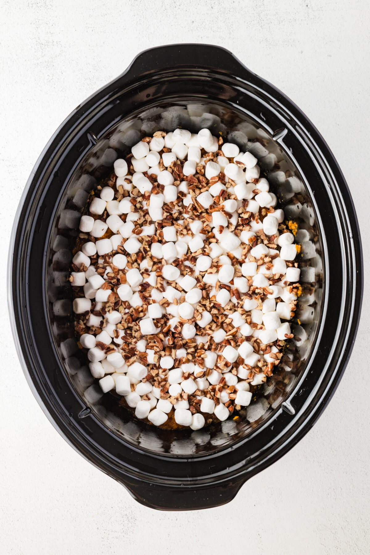 chopped pecans and marshmallows over the sweet potatoes in a crockpot