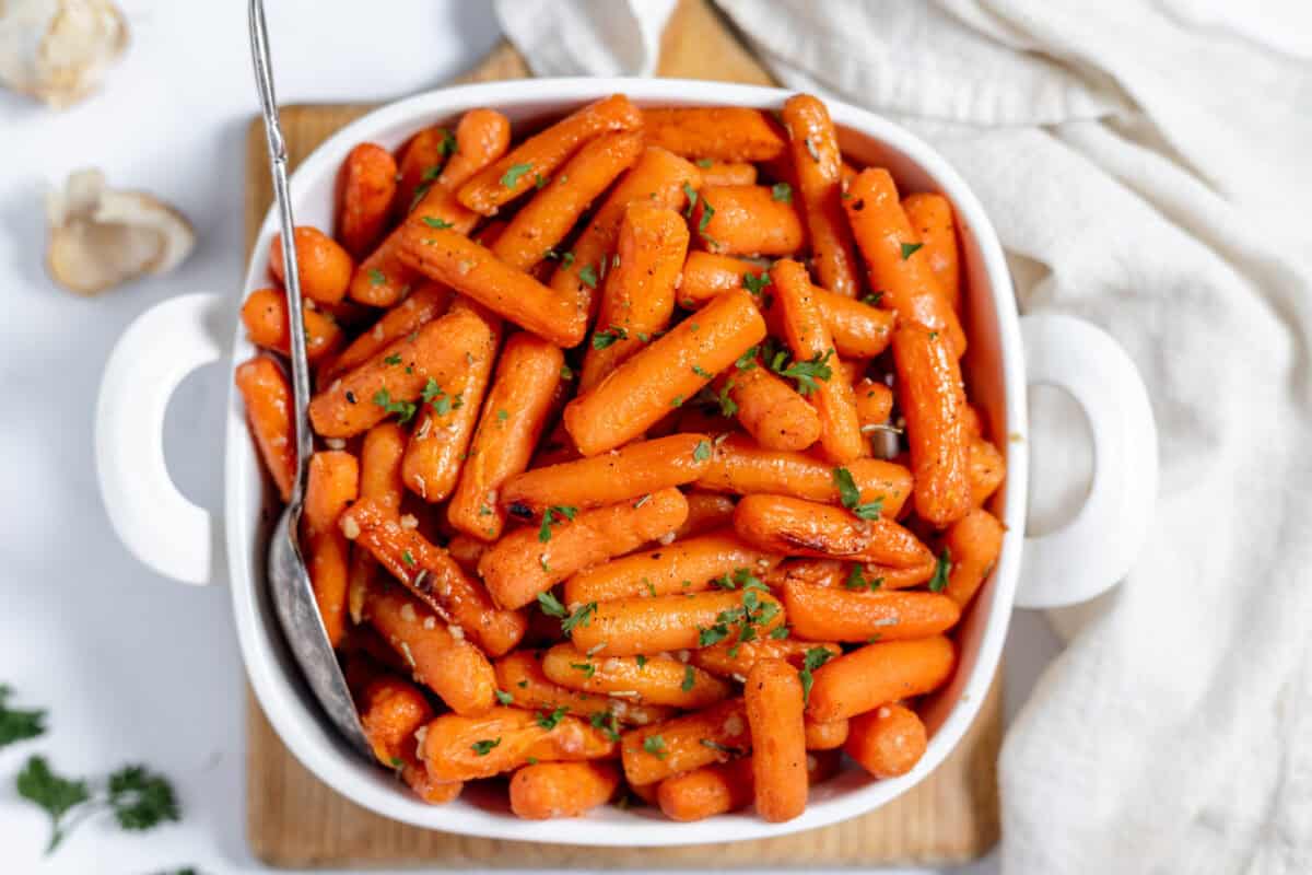 roasted baby carrots in a white dish