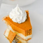 slice of pumpkin cheesecake pie with a bite on a fork