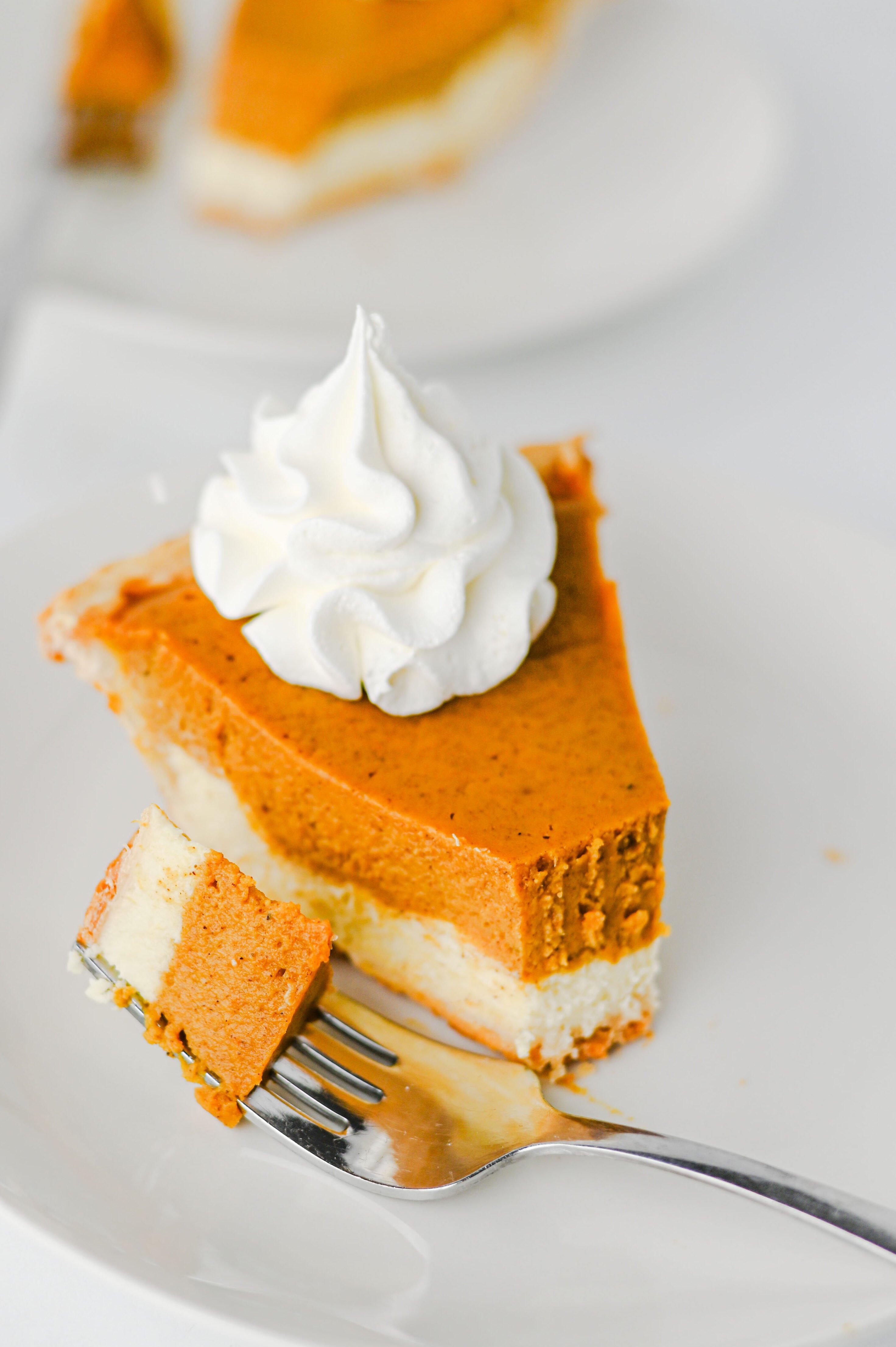 slice of pumpkin cheesecake pie with a bite on a fork