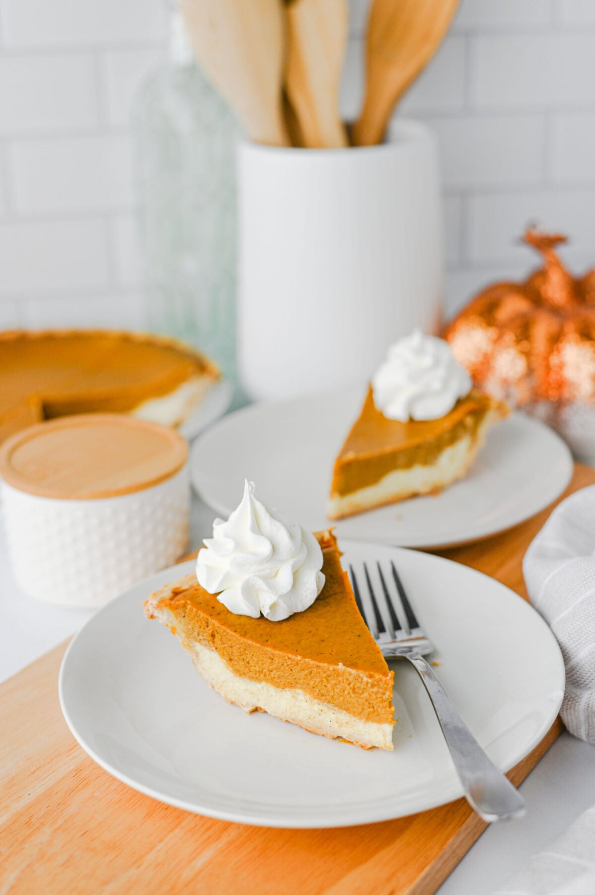 slices of pumpkin pie cheesecake on white plates