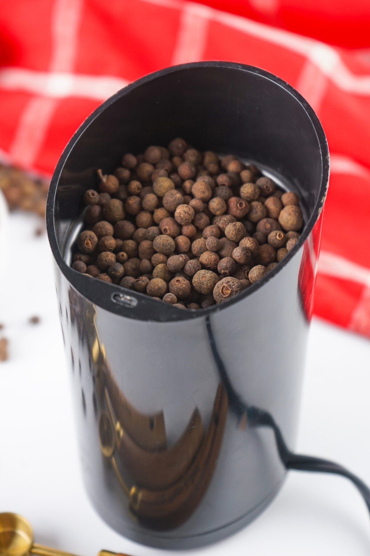 whole allspice berries in a spice grinder