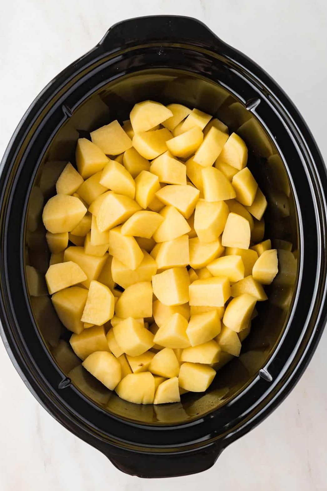 raw cubed potatoes in a slow cooker