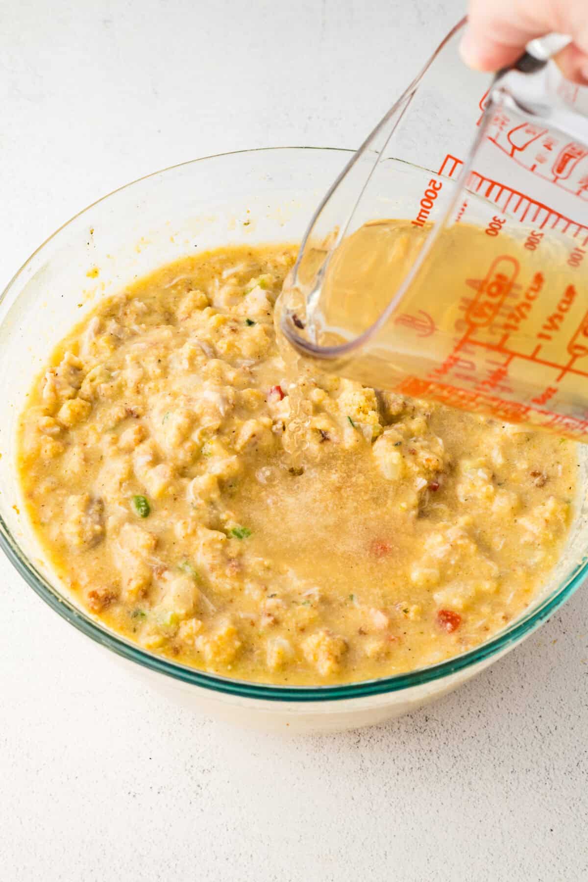 pouring broth into cornbread mixture