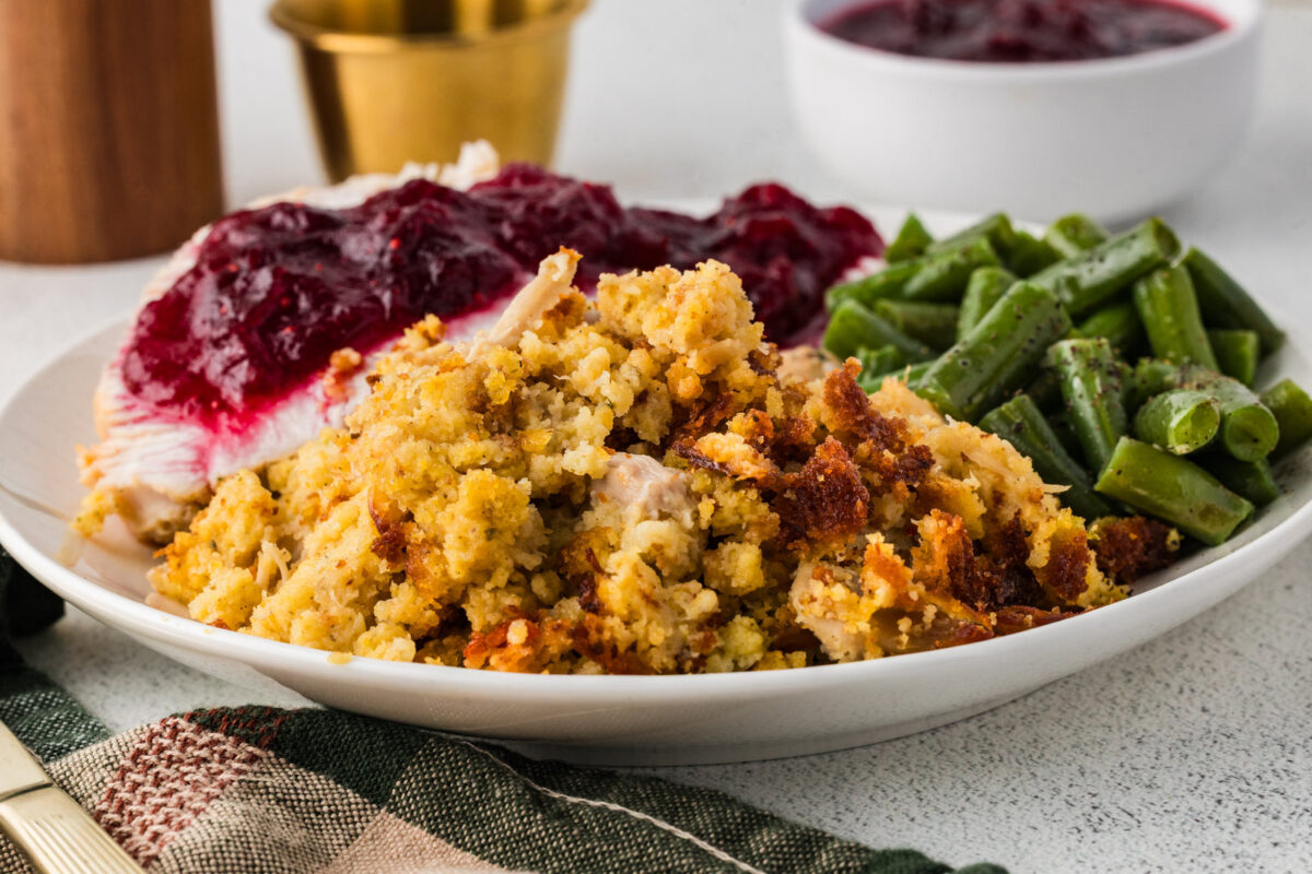 southern cornbread dressing on a plate with turkey, cranberry sauce and green beans