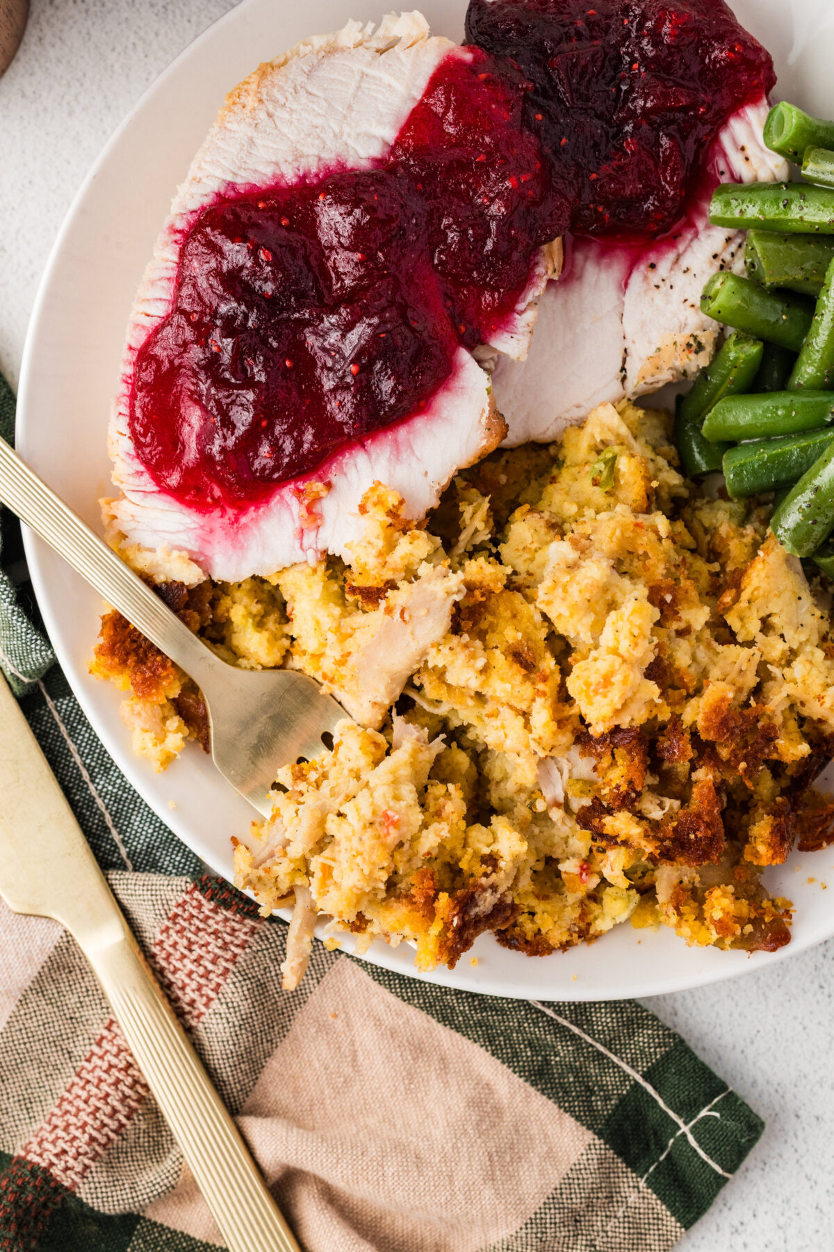 southern cornbread dressing on a plate with turkey, cranberry sauce and green beans