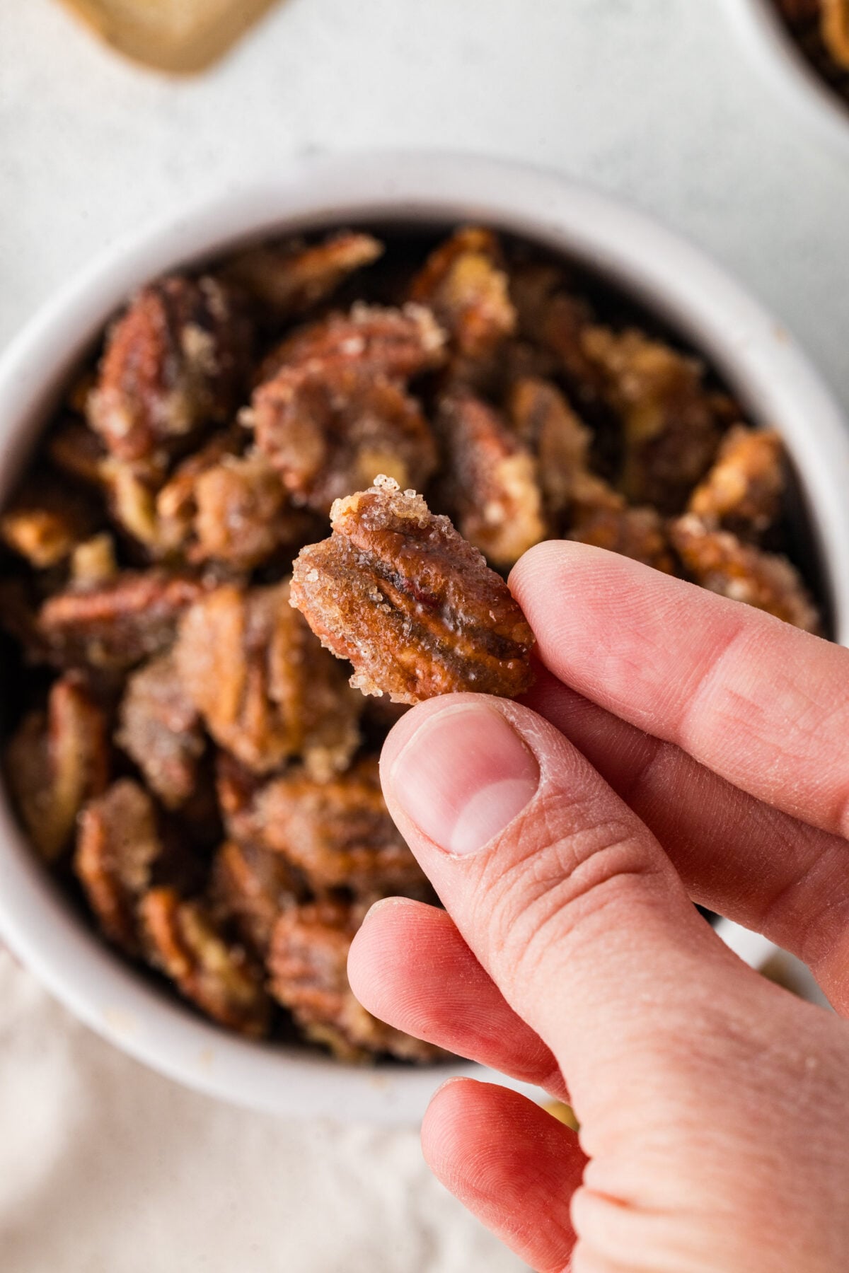 a hand holding a spiced pecan