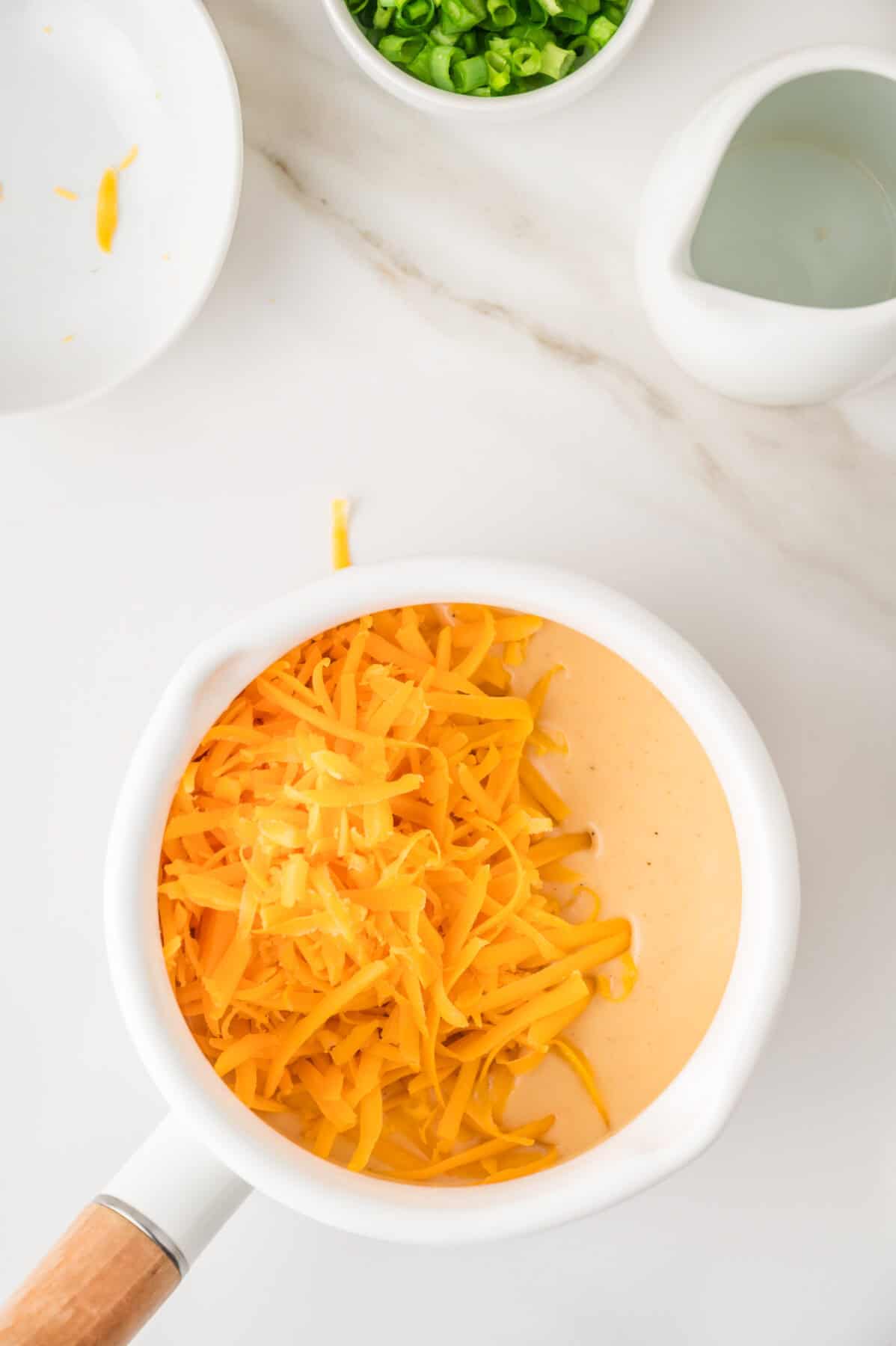 adding cheese to the sauce