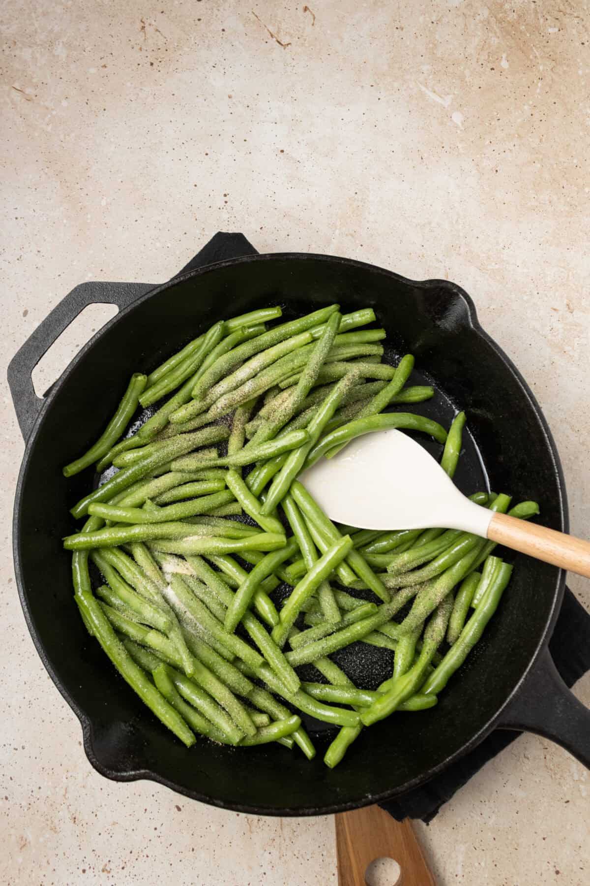 seasonings added to green beans in skillet