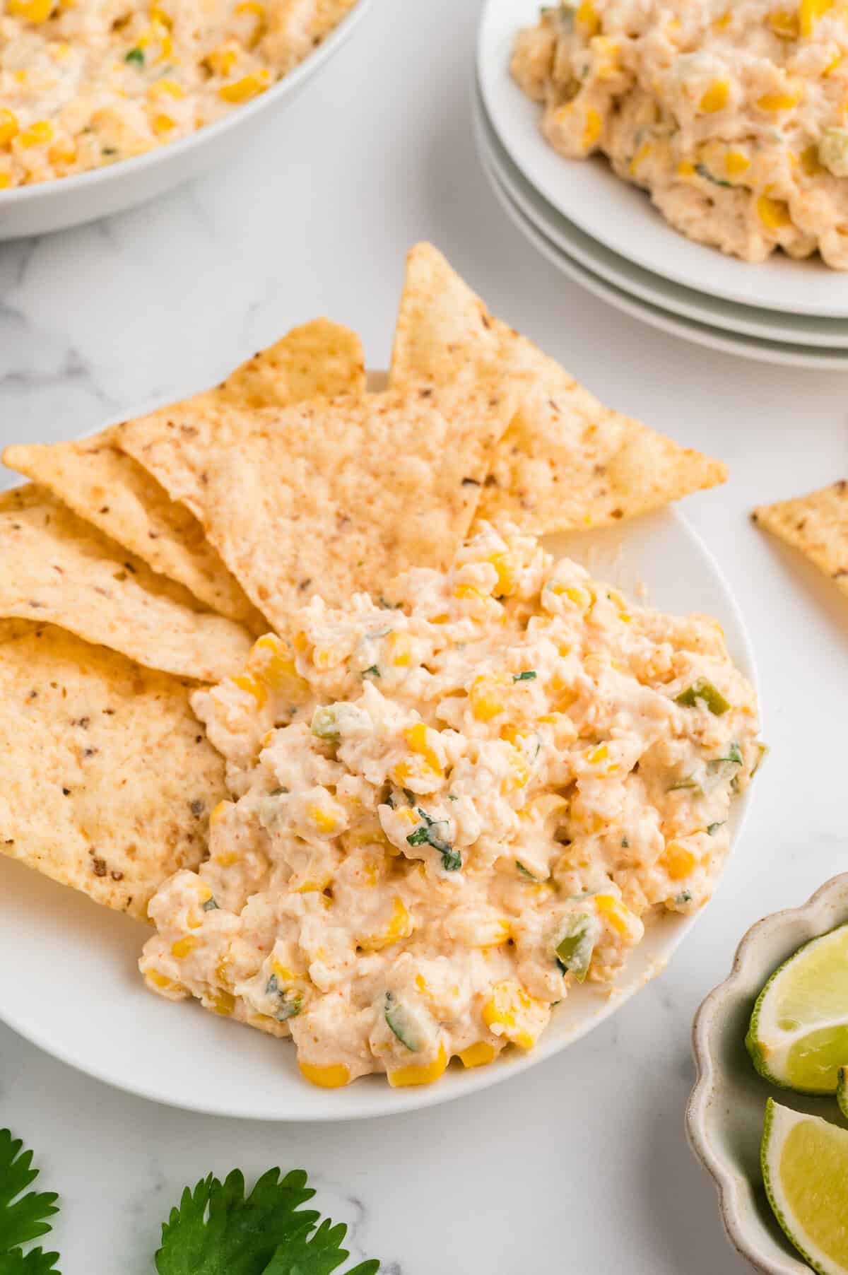 bowl of mexican street corn dip surrounded by tortilla chips